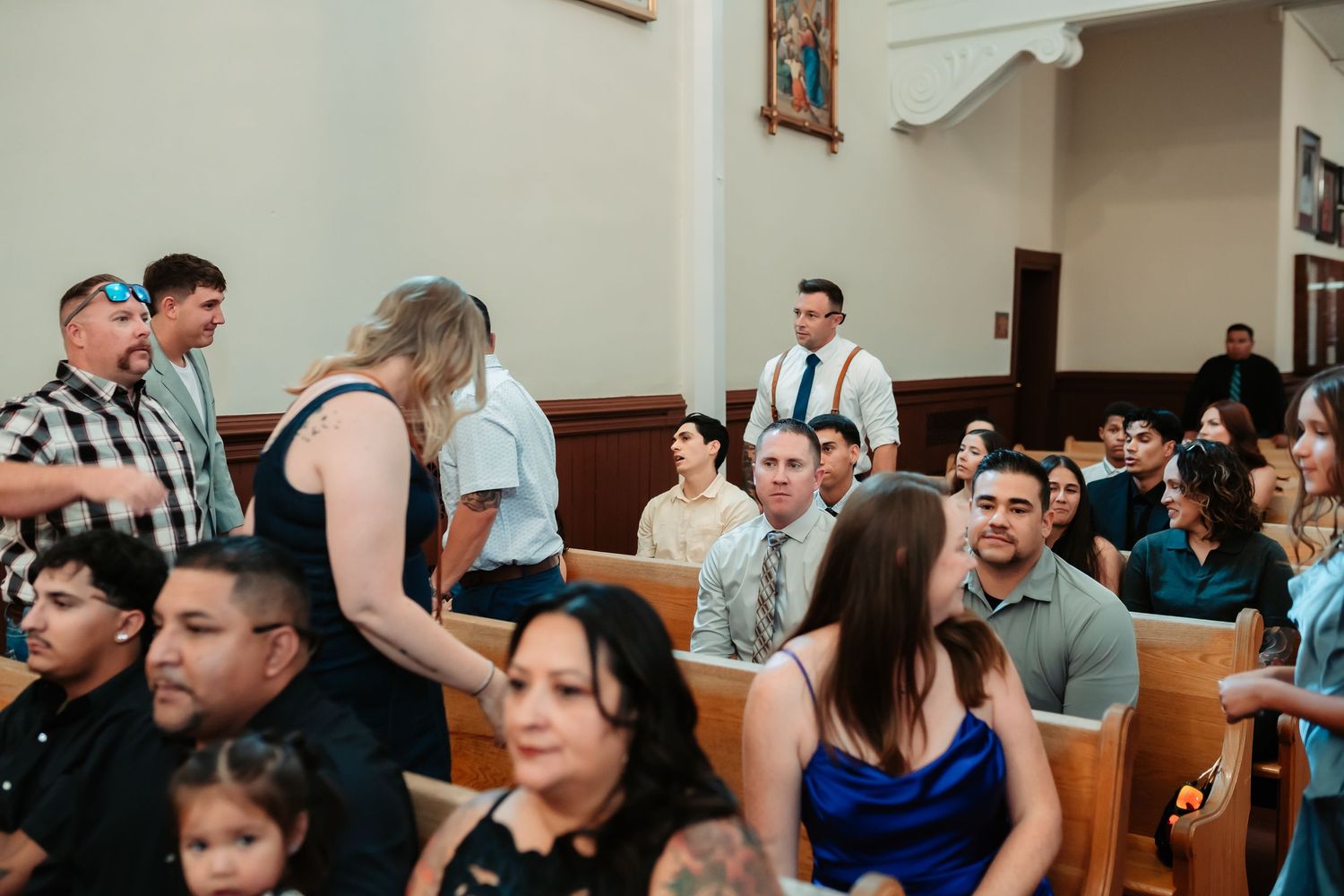 A group of people gathered together in a church interior gazing upward during what appears to be a service.
