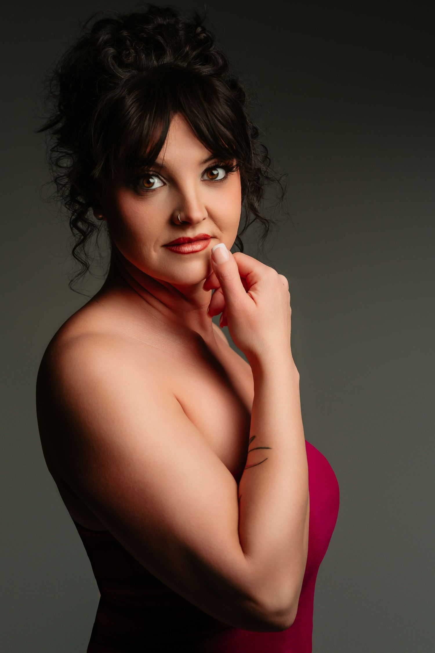 A series of artistic portrait photographs showing a person in a dark setting wearing a red garment against a moody backdrop.
