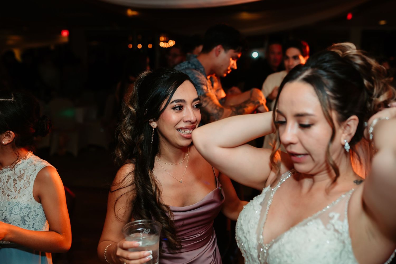 Dance floor filled with joyful wedding guests celebrating during an evening reception.