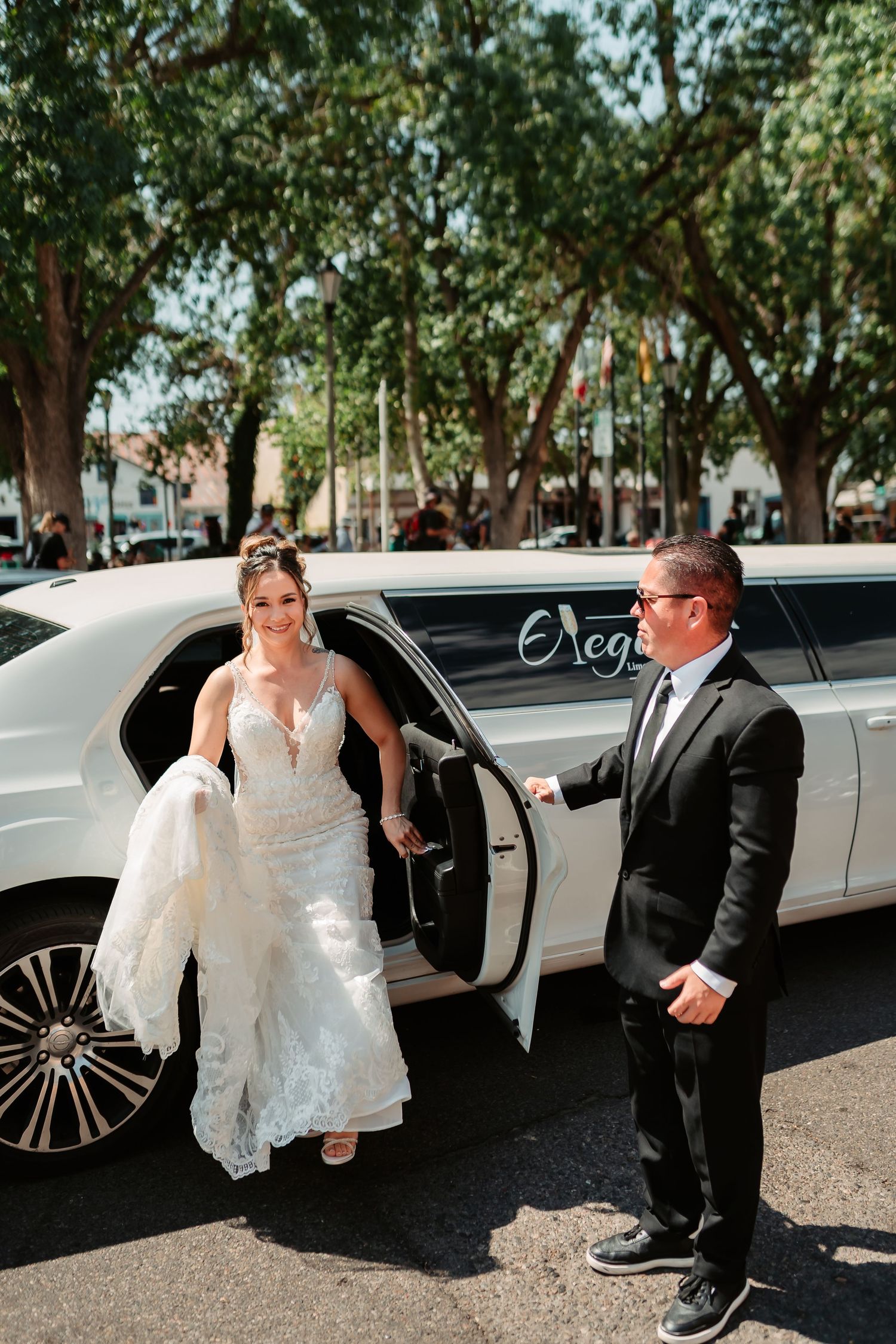 Elegant white limousine arrival scene with a bride in a flowing white dress stepping out at a wedding venue.
