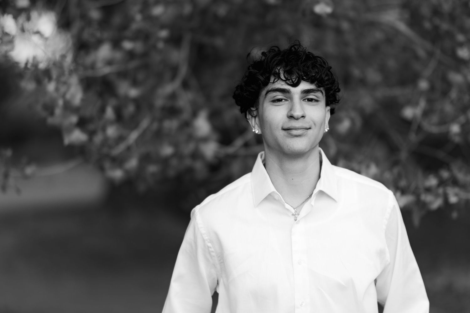 Black and white portrait showcasing classic white collar shirt in natural setting.