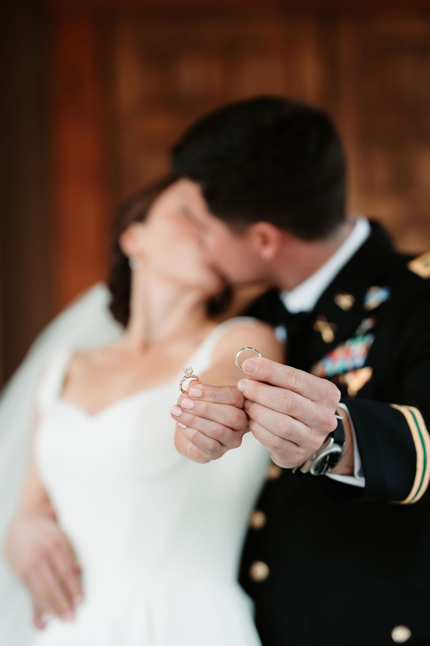 A couple shares an intimate moment during their wedding as the groom wears a military dress uniform.