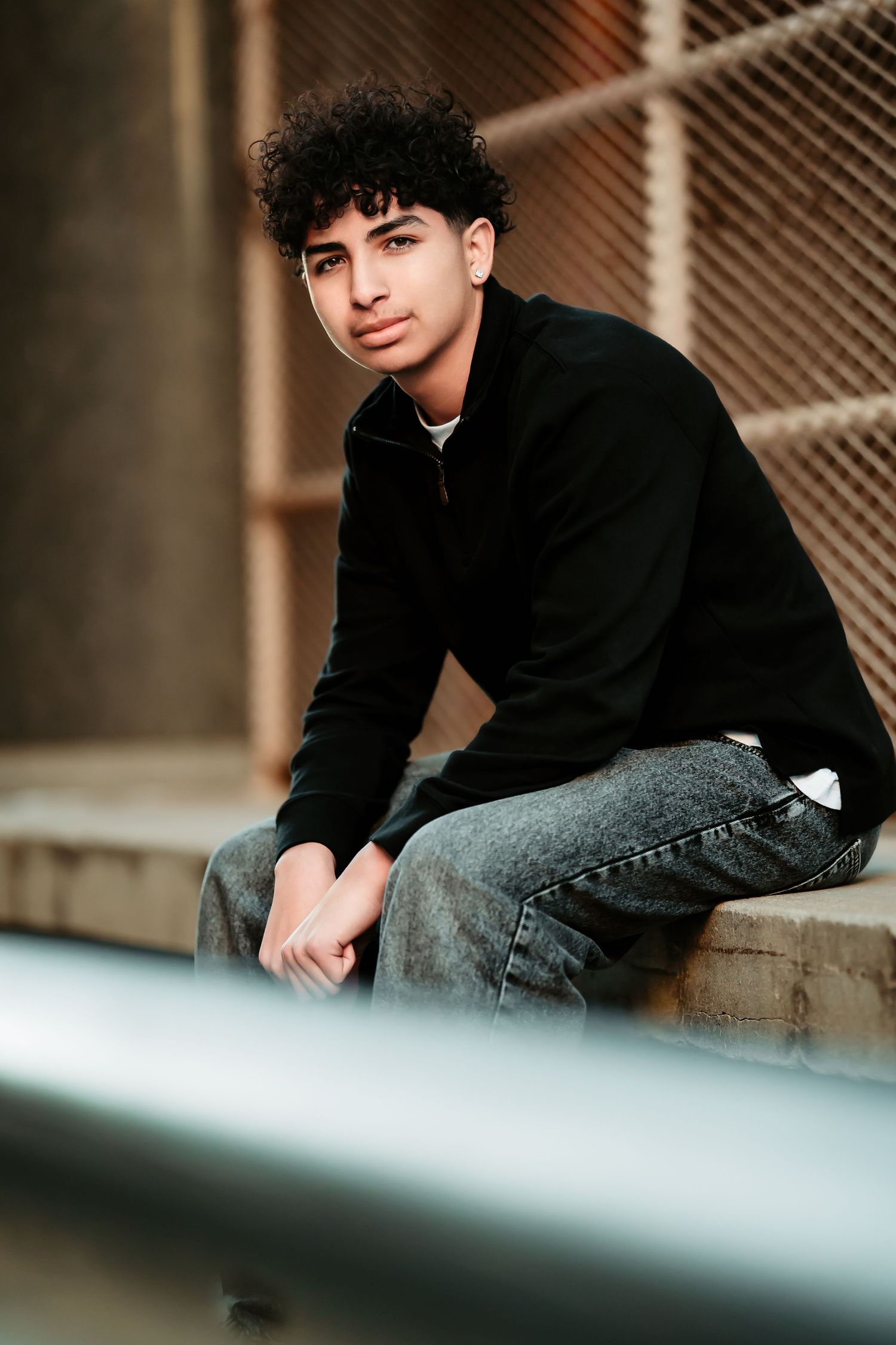 Moody portrait series captured against an industrial backdrop with soft natural lighting and urban aesthetics.