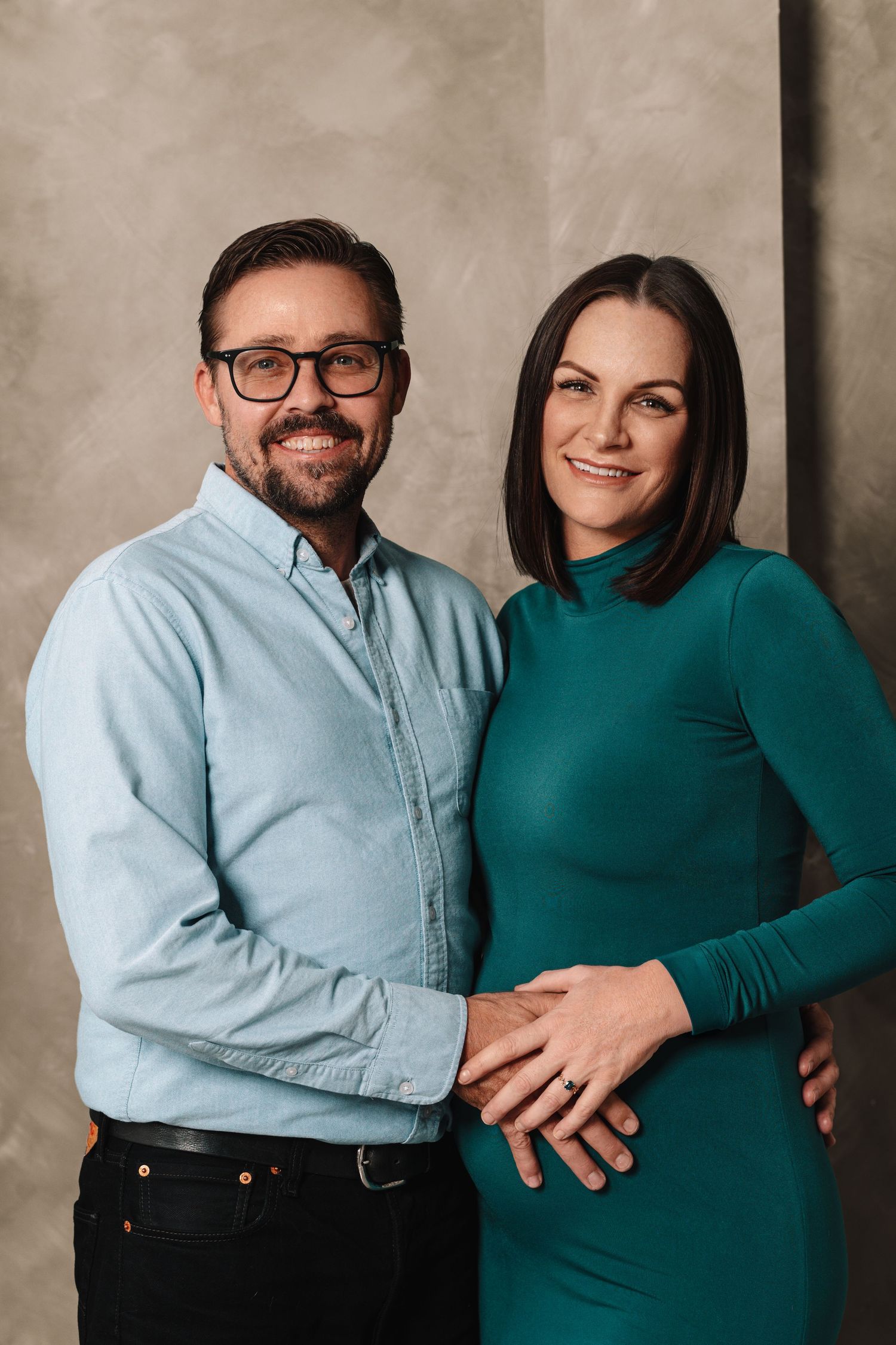 A series of four intimate portrait shots showing a couple in light blue and teal clothing against a neutral backdrop.