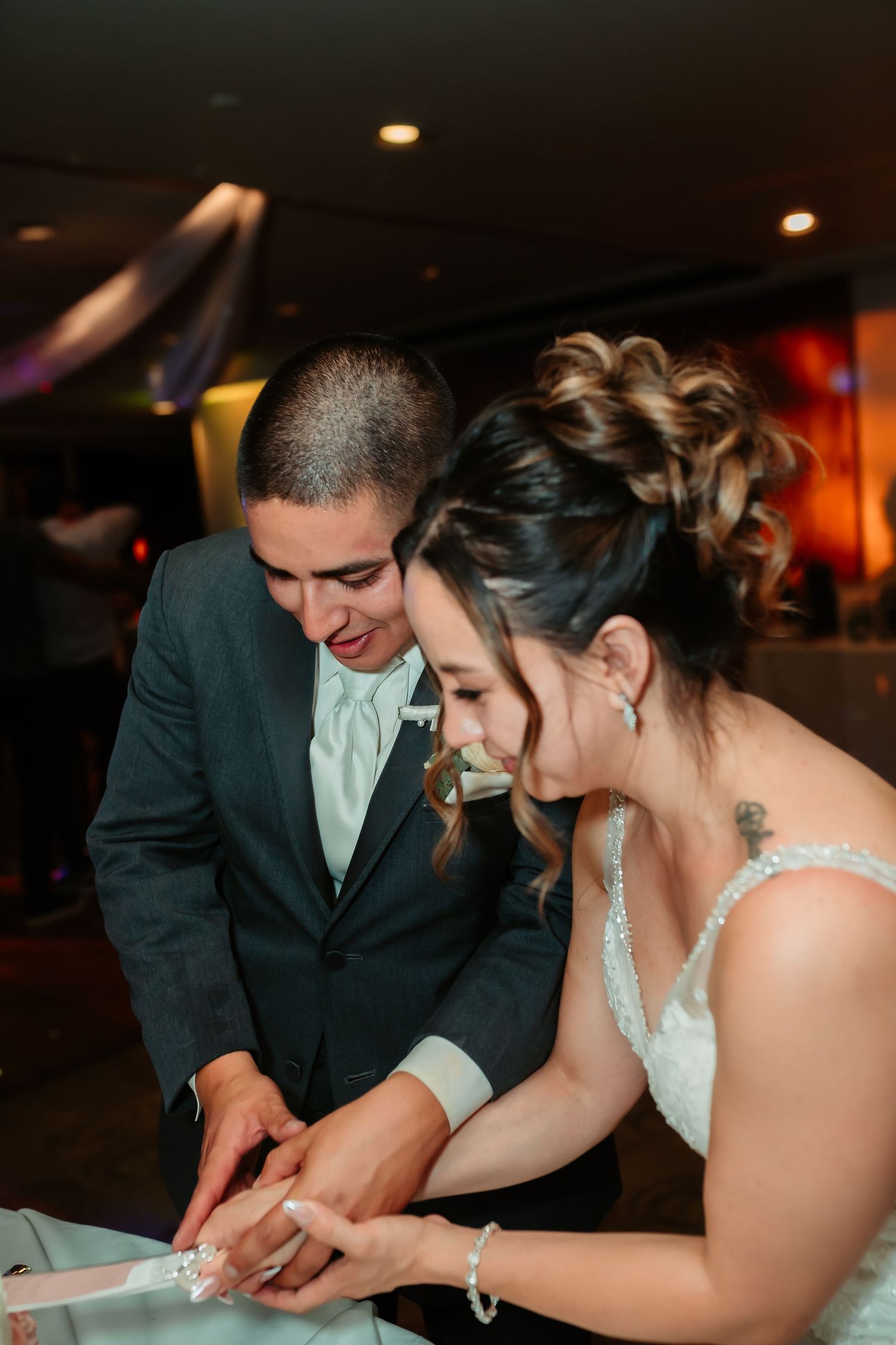 Newlyweds signing their marriage certificate together at reception venue.
