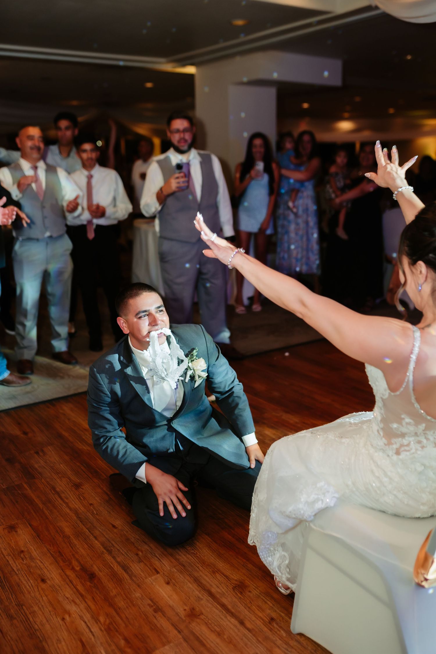 A couple performs a dramatic wedding dance on a wooden floor at their reception.