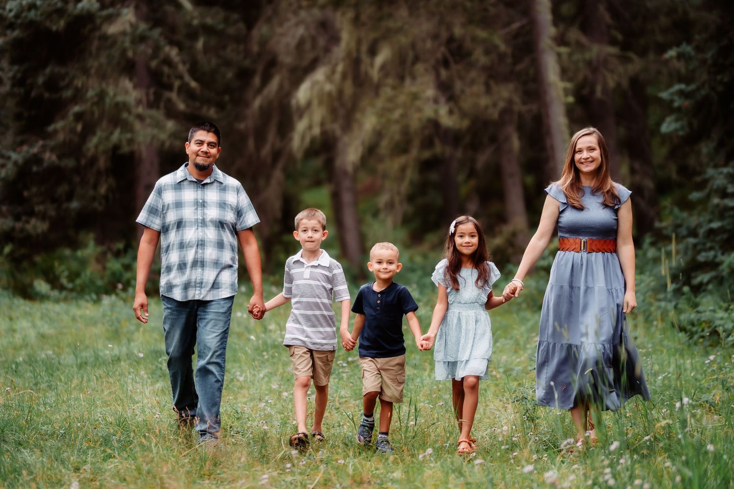 Family walking together through a lush green meadow on a sunny summer day.