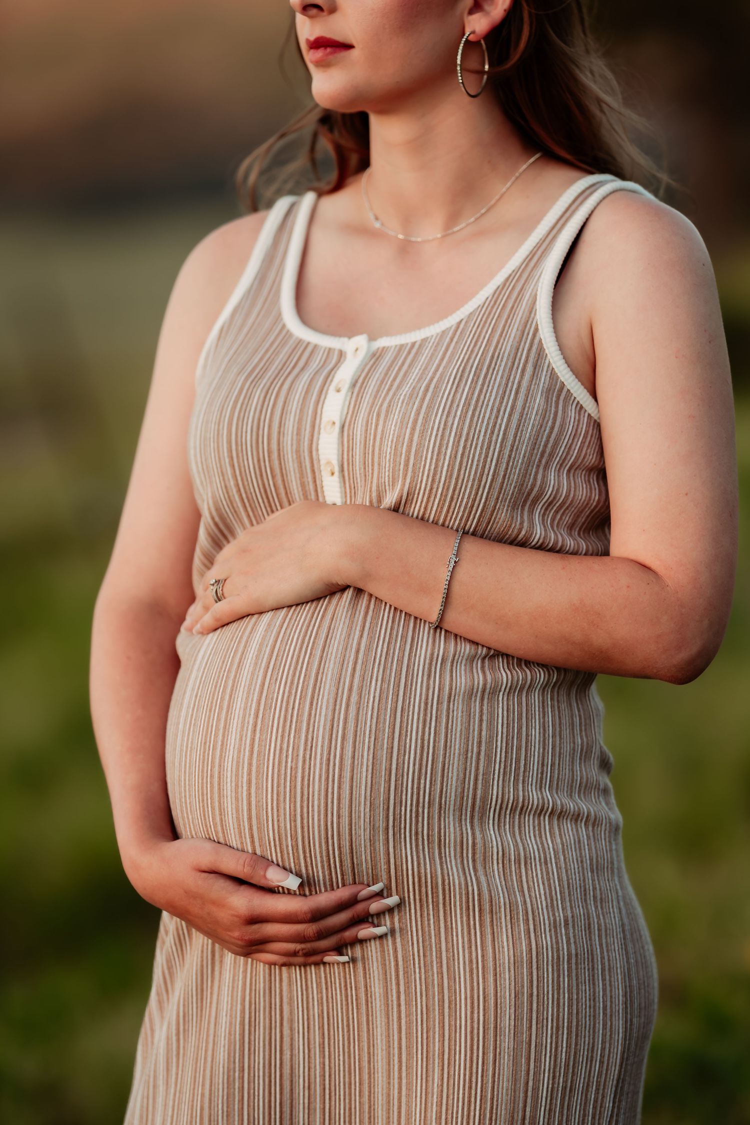 A series of maternity photos showing a pregnant person wearing a beige ribbed dress while gently cradling their belly.