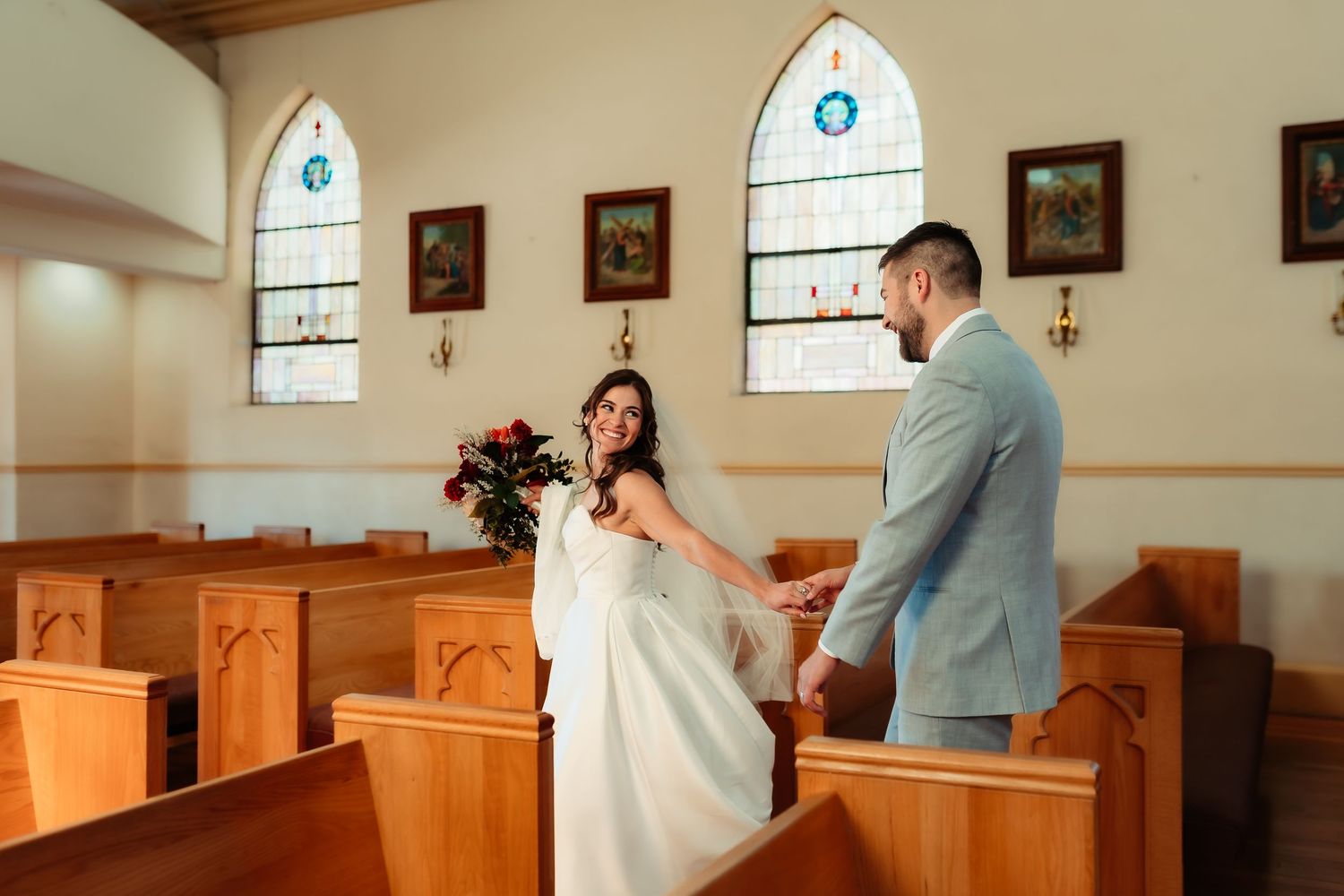 A couple stands together in a traditional church sanctuary during their wedding ceremony.