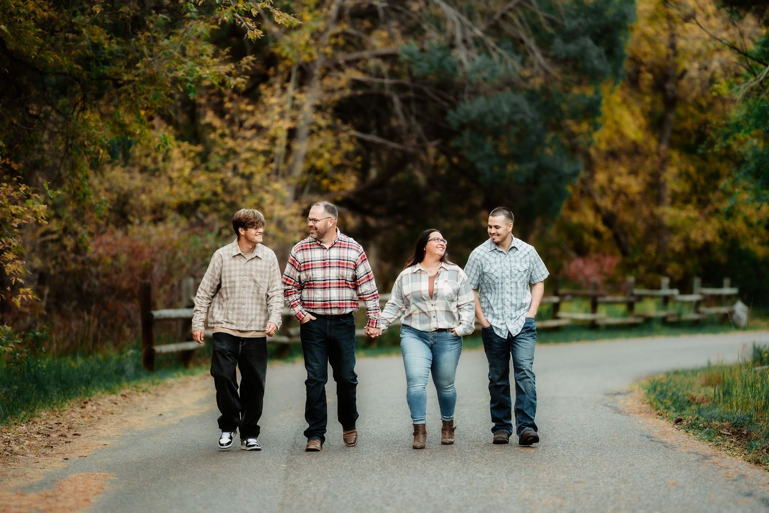 A group of people walking together down a tree-lined path in autumn.