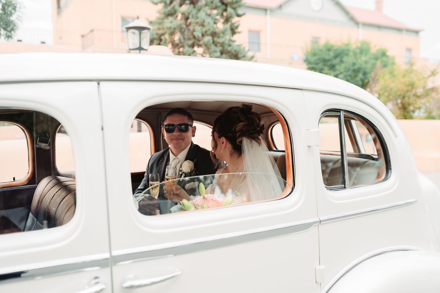 Series of four photos showing newlyweds in classic white car during wedding celebration.