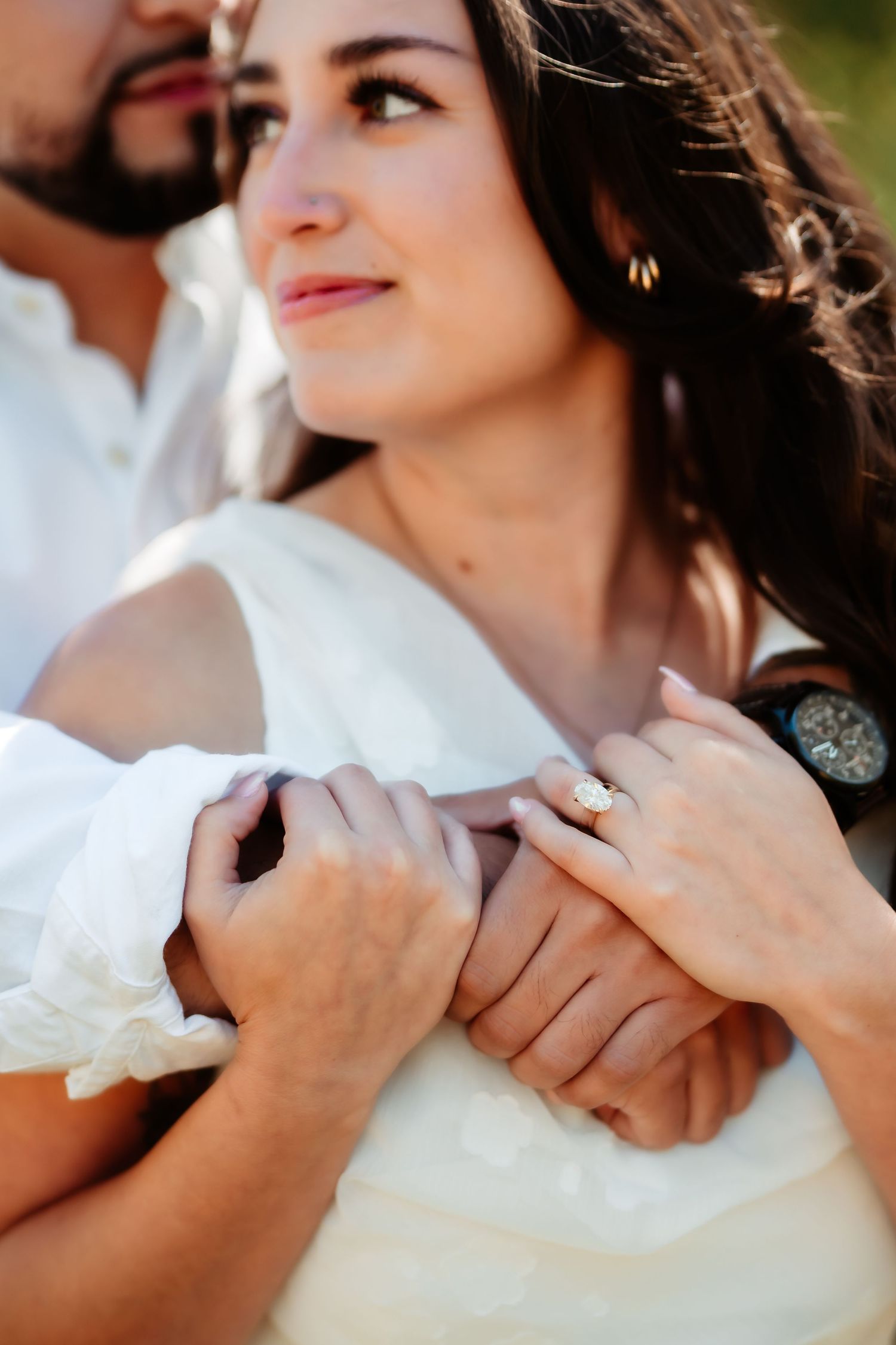 A close-up sequence of hands showing an engagement ring during a romantic outdoor photo session.