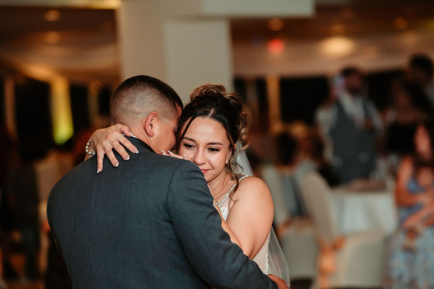 A series of romantic dance moments captured at an indoor wedding reception in warm ambient lighting.