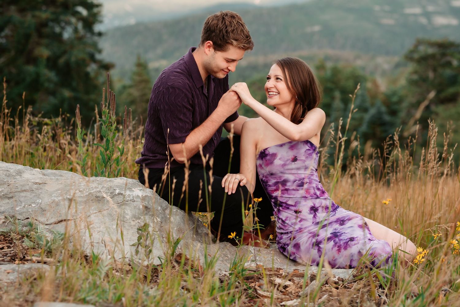 A romantic moment shared on a rocky outcrop surrounded by mountain wildflowers.