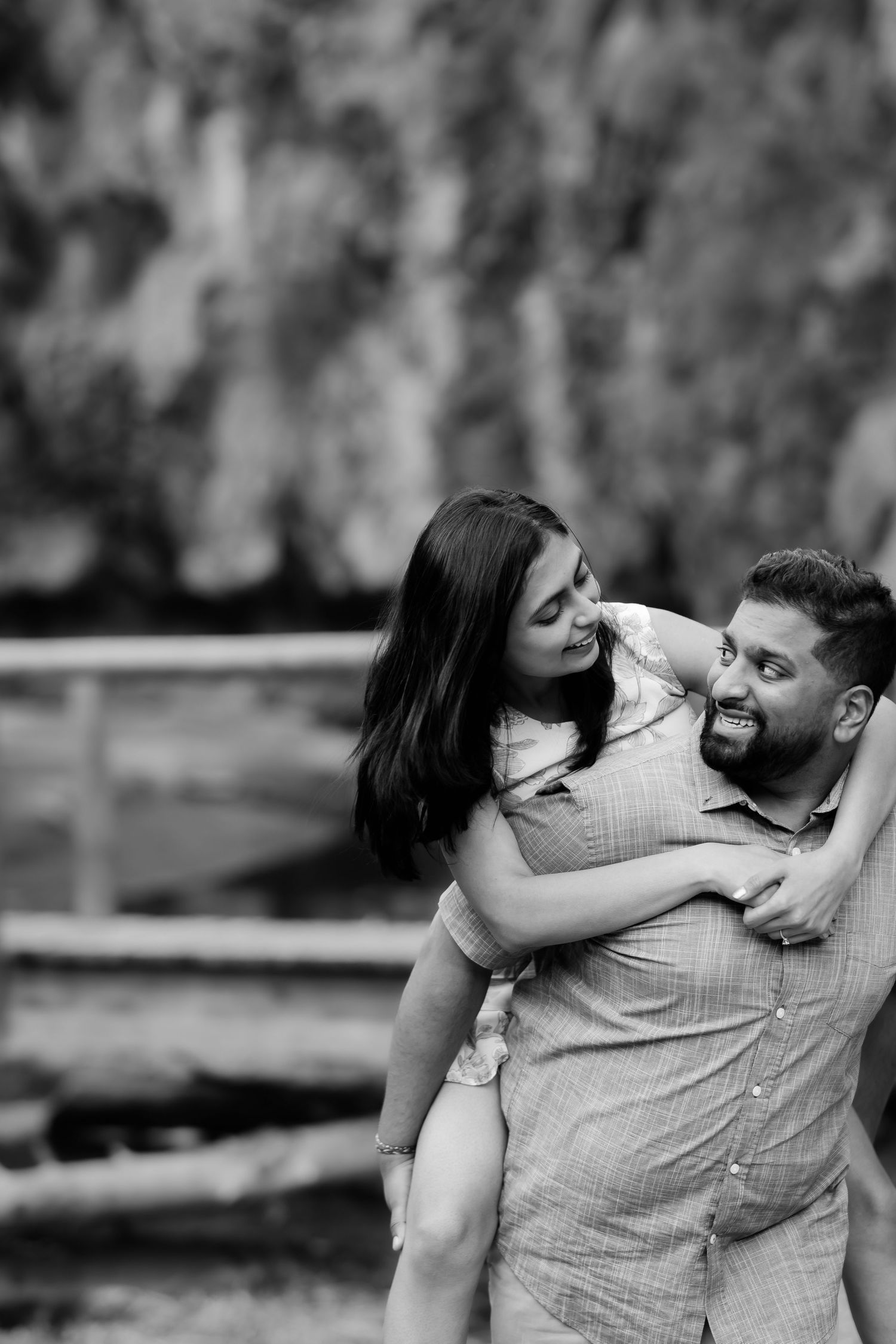 A playful black and white portrait of a couple sharing a joyful moment together.