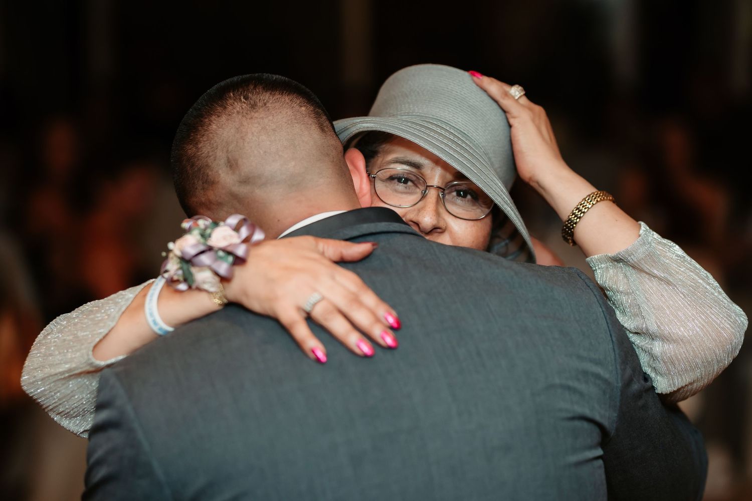 An intimate embrace captured in soft lighting during an emotional wedding moment.