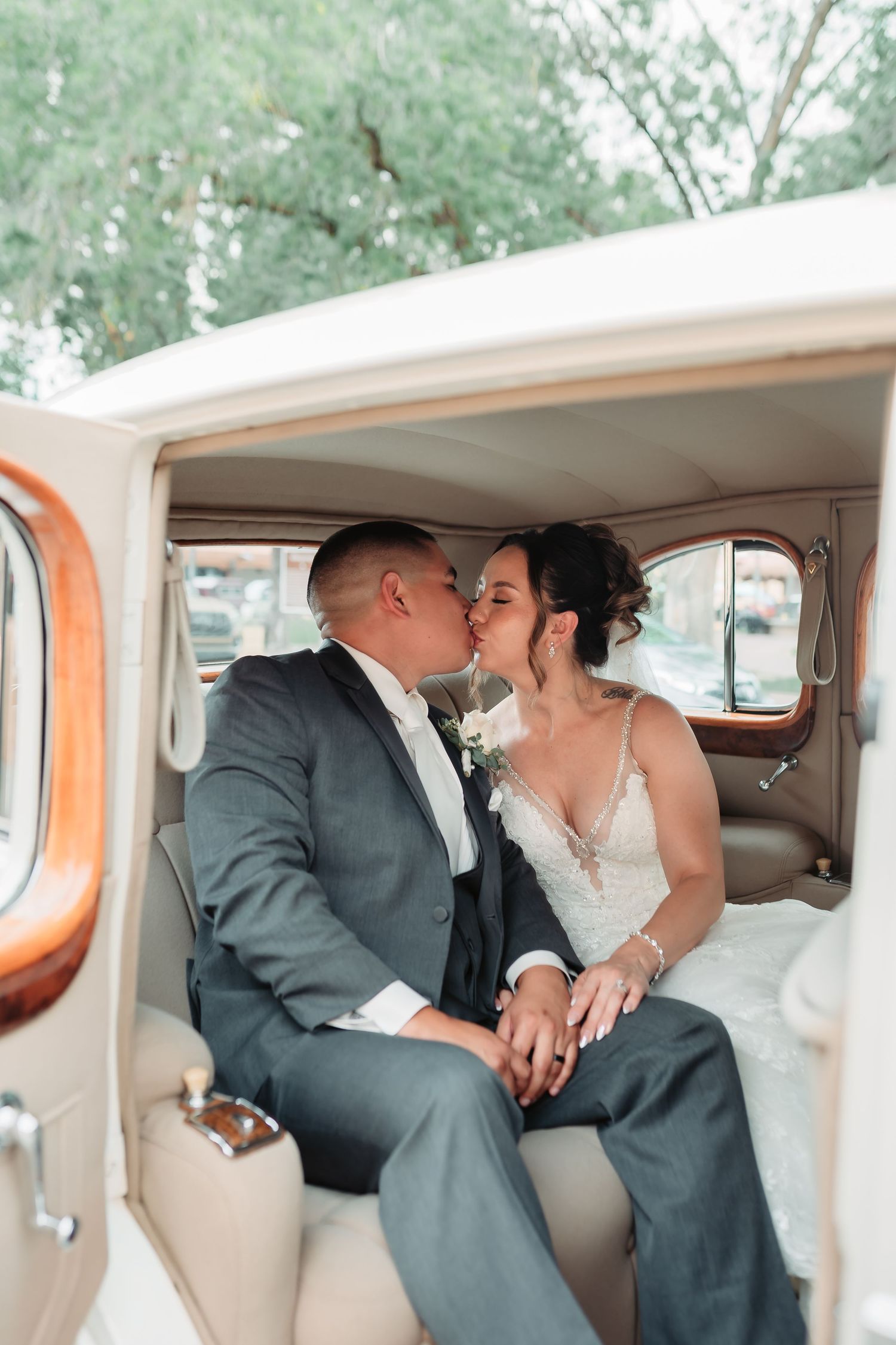 Romantic moment captured inside a vintage car with cream and orange interior.