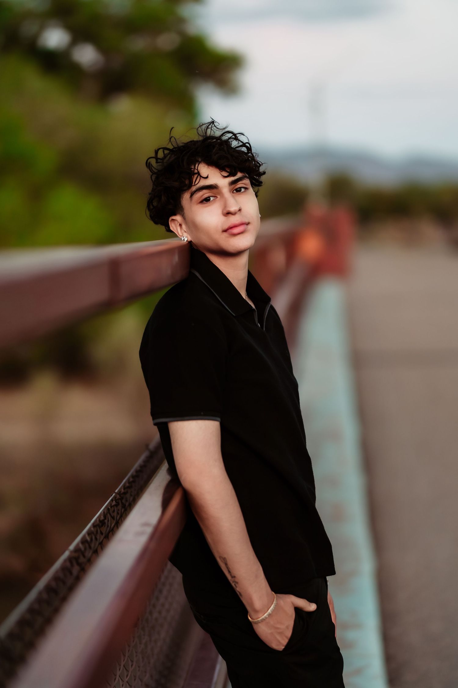 Portrait photo series showing someone in black clothing posing against a blurred outdoor background at sunset.