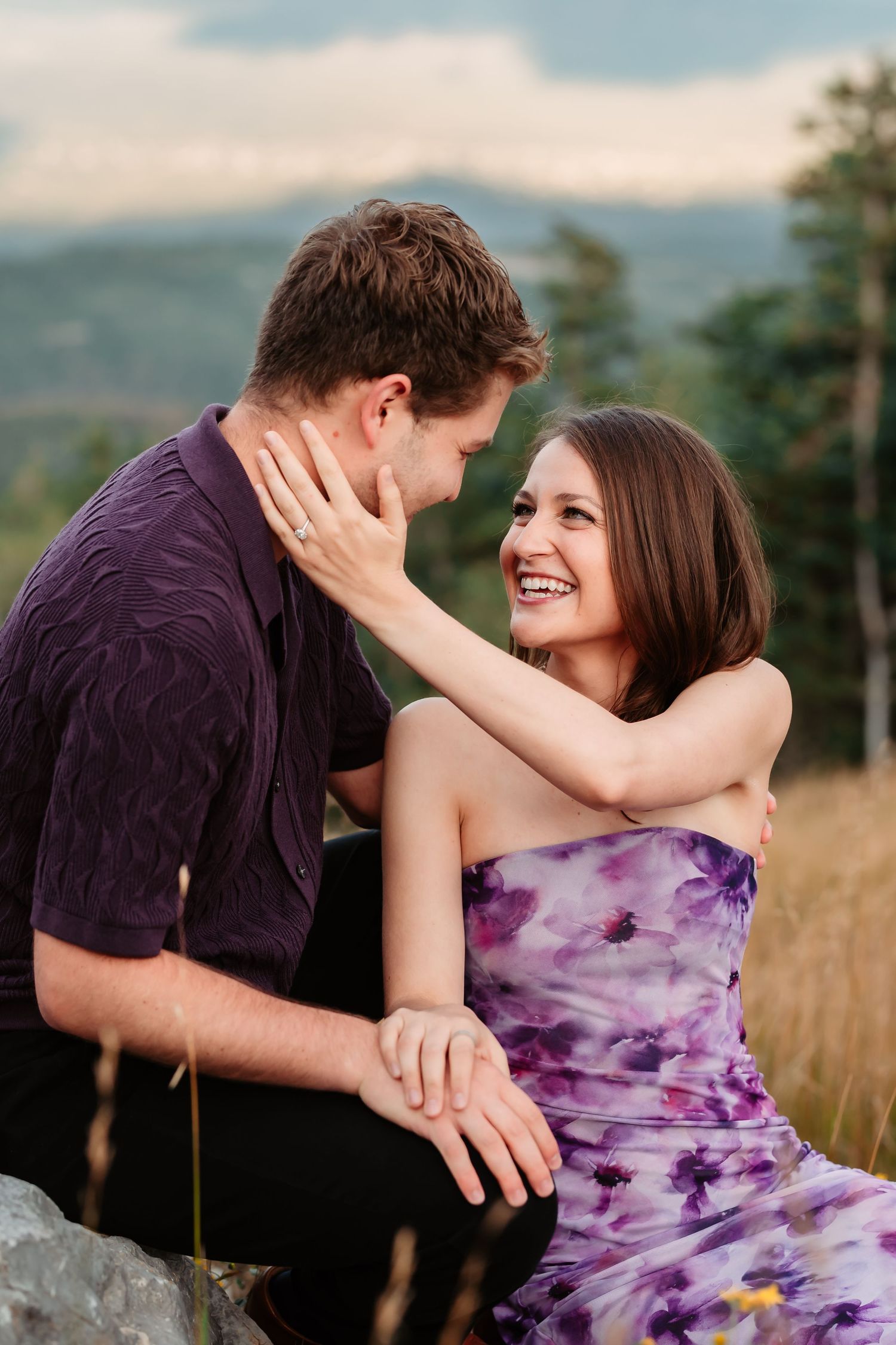 A romantic couple embraces in a golden mountain meadow during sunset.