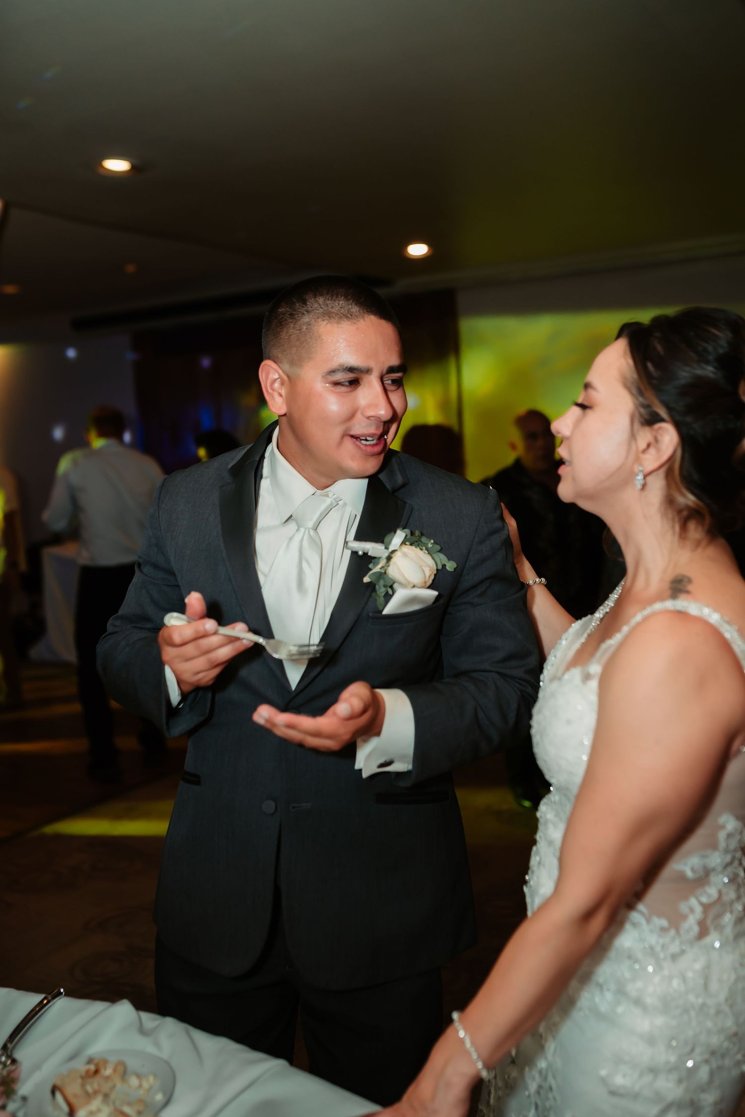 Couple shares a fun cake-feeding moment during their wedding reception celebration.