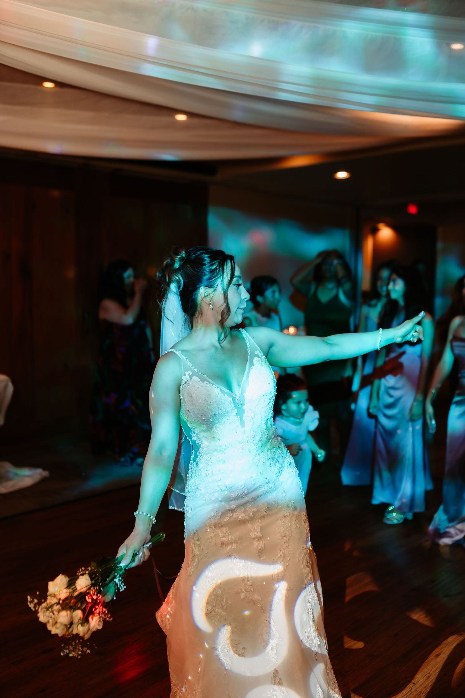 Wedding dance floor with blue lighting and guests dancing in formal attire.