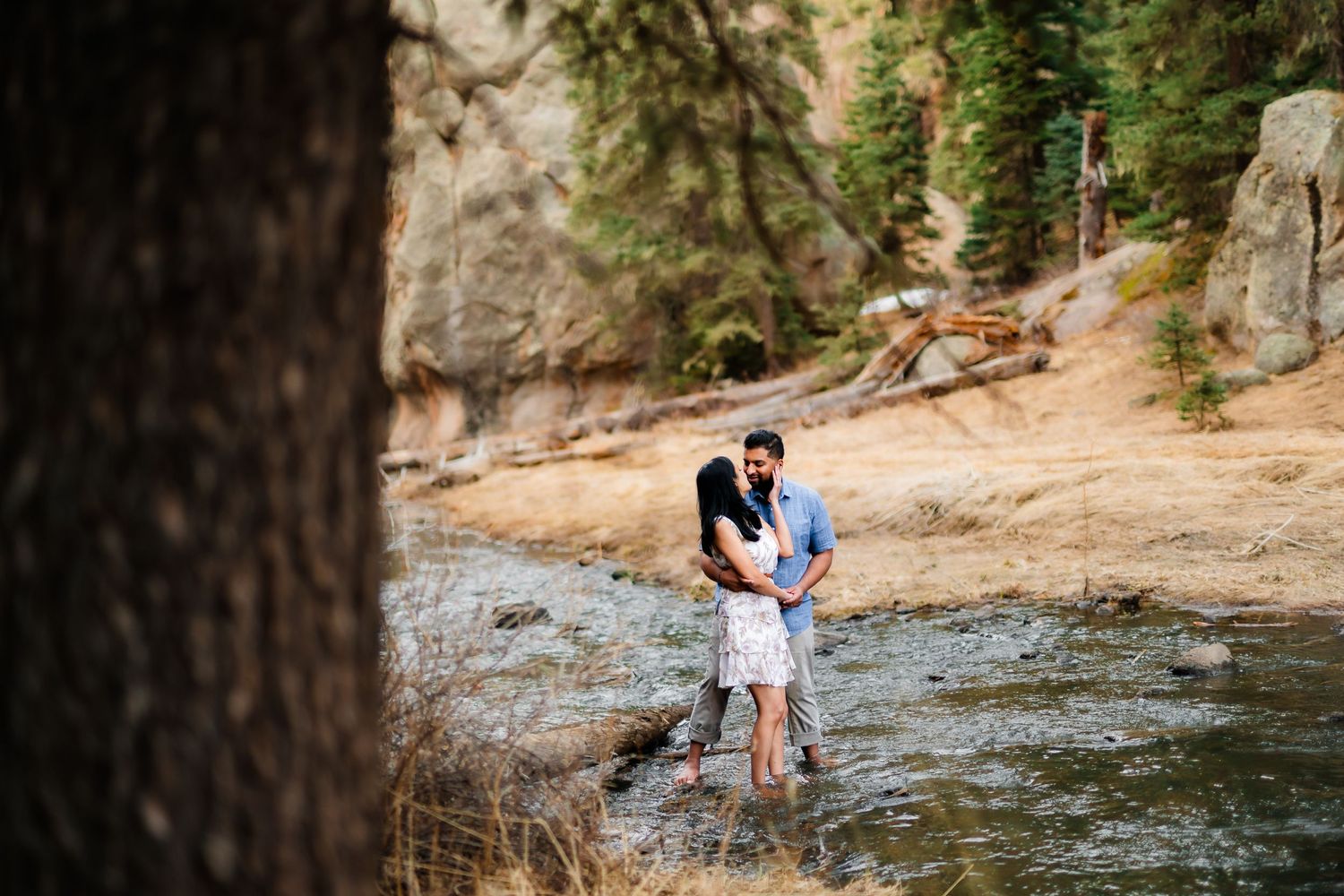 Romantic couple standing together in a scenic mountain stream during their photo session.
