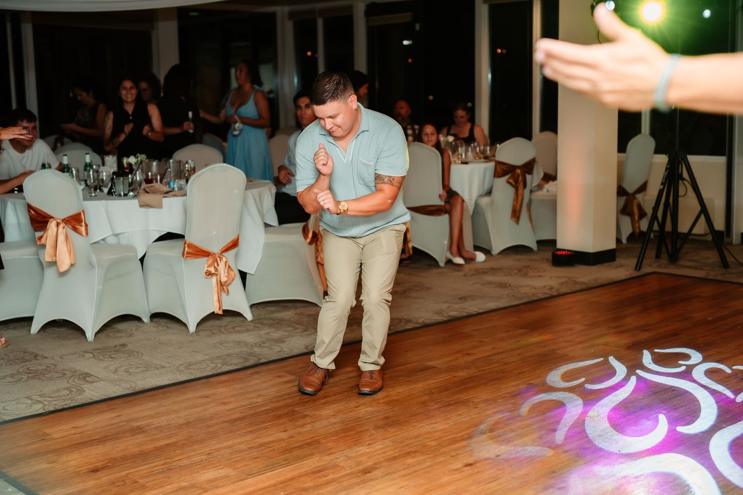 A guest dances solo on a wooden floor with decorative lighting patterns.
