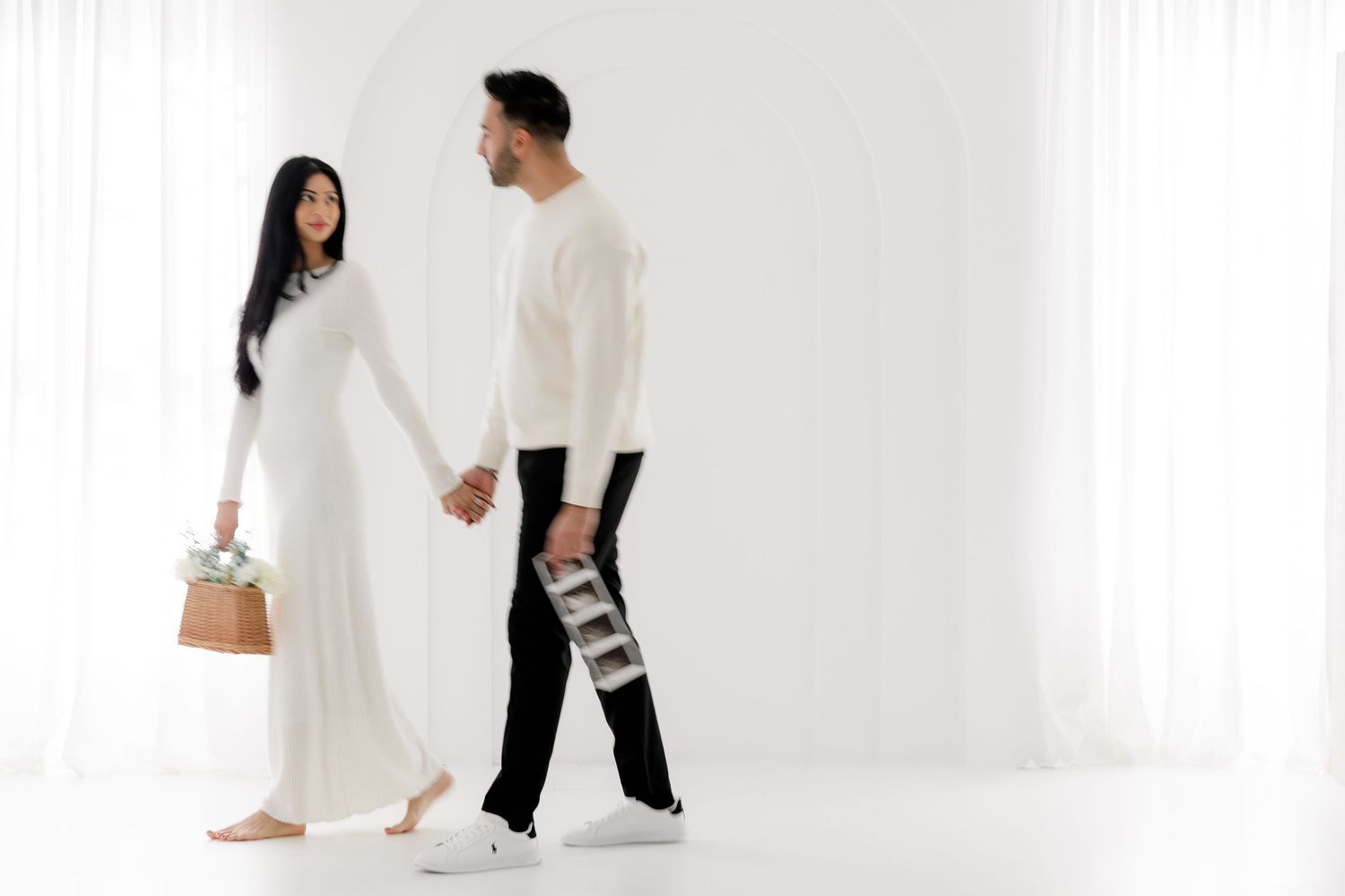 Contemporary couples maternity session in black and white outfits against white studio background.