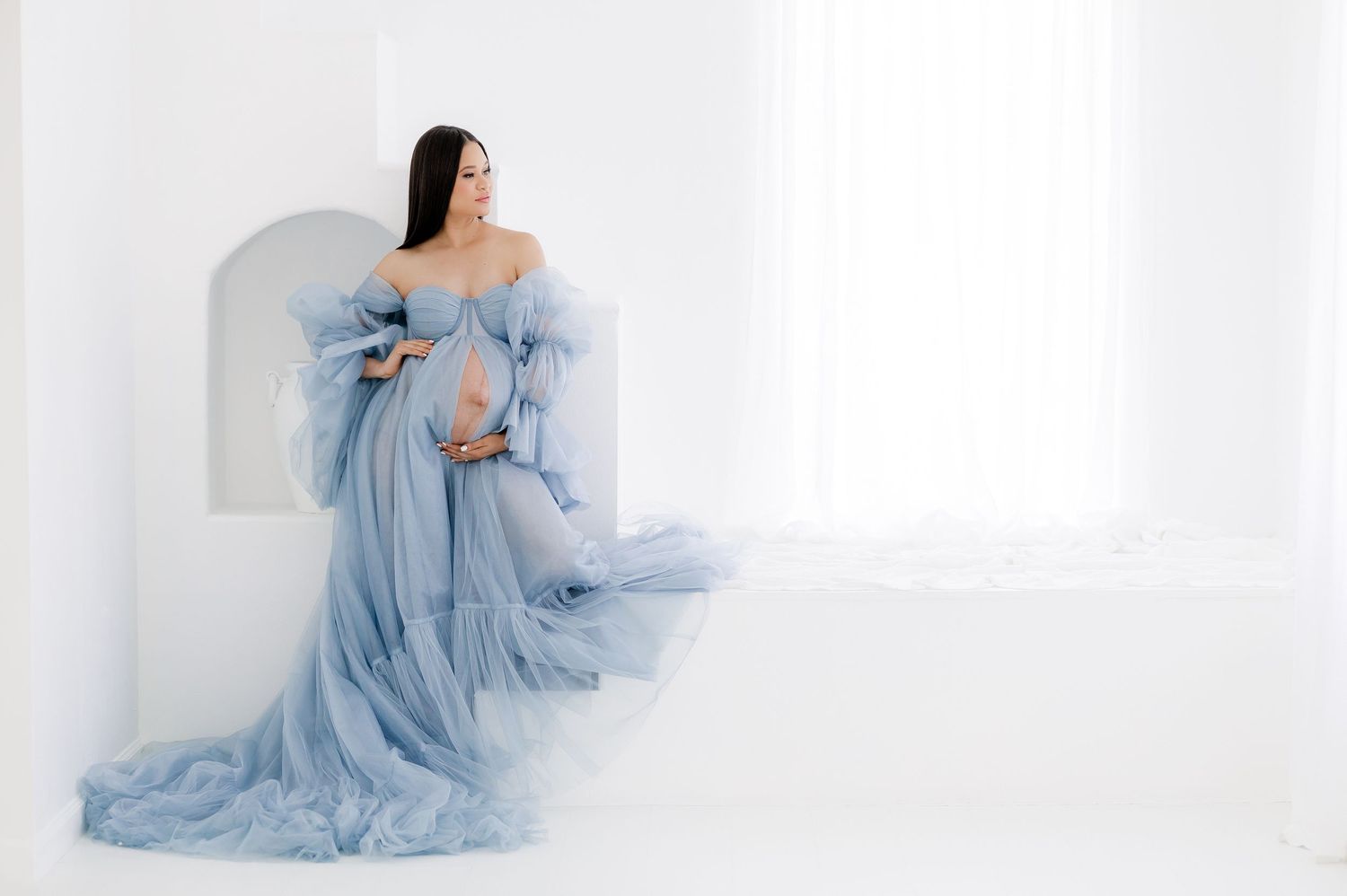 Graceful maternity photography series in light blue flowing dress.