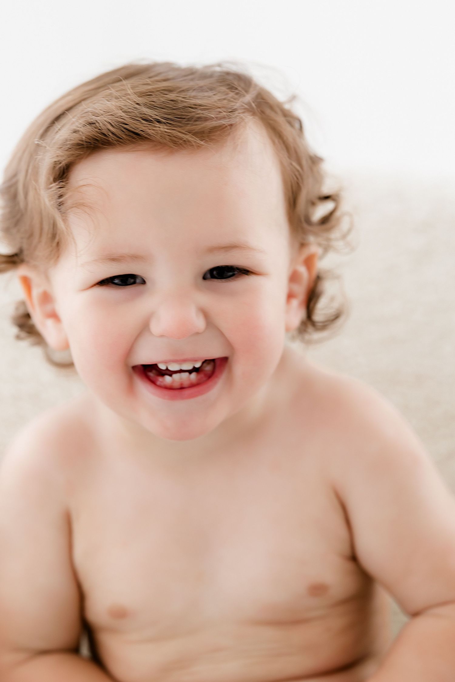 Close-up portrait showing joyful expression against white background.