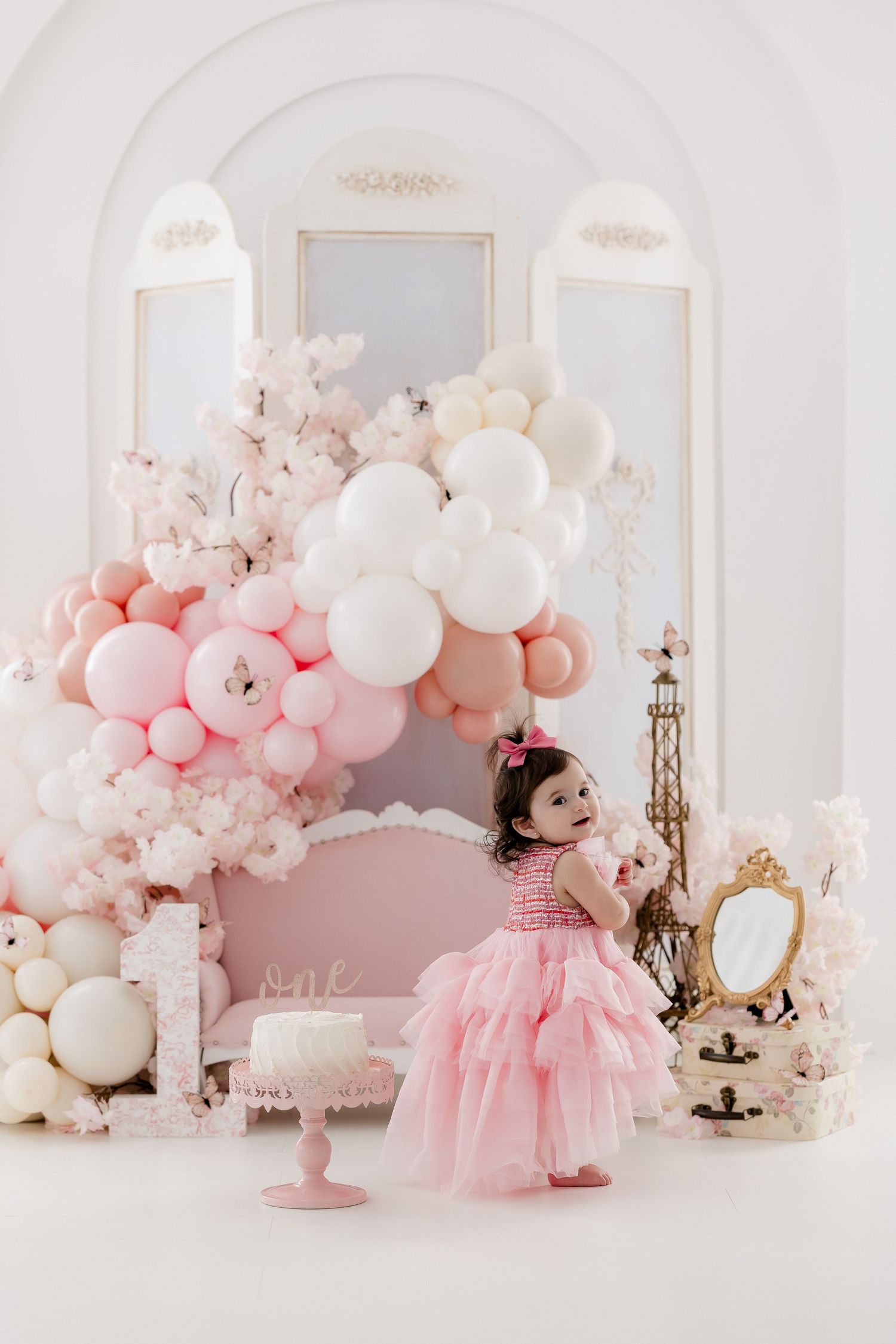 Pink princess birthday setup with balloon arch and vintage gold mirror decor.