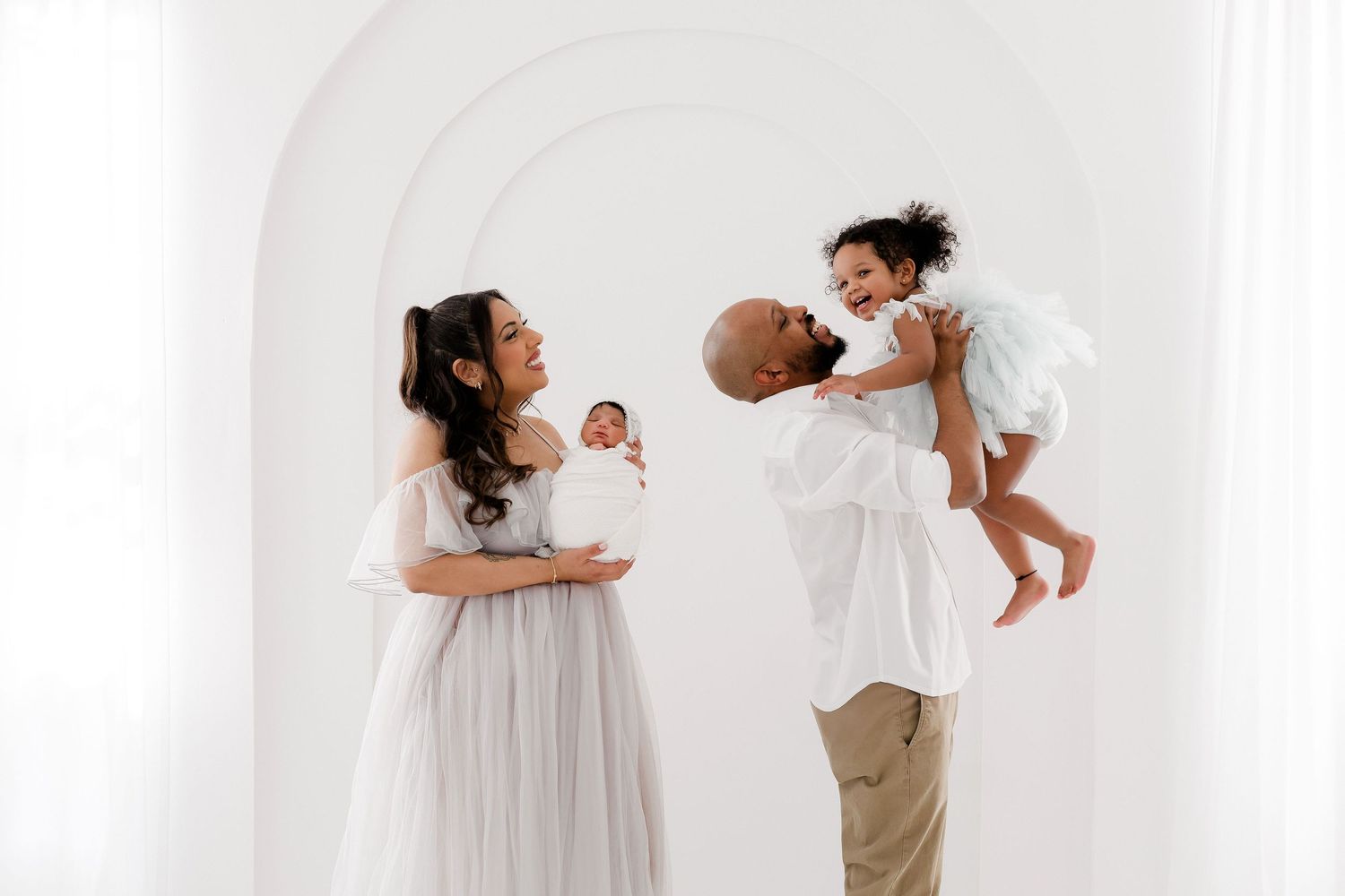 Artistic series of family poses in white studio setting.