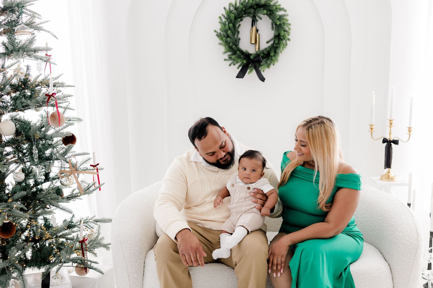 Holiday studio photos with Christmas trees and wreaths in bright white setting.