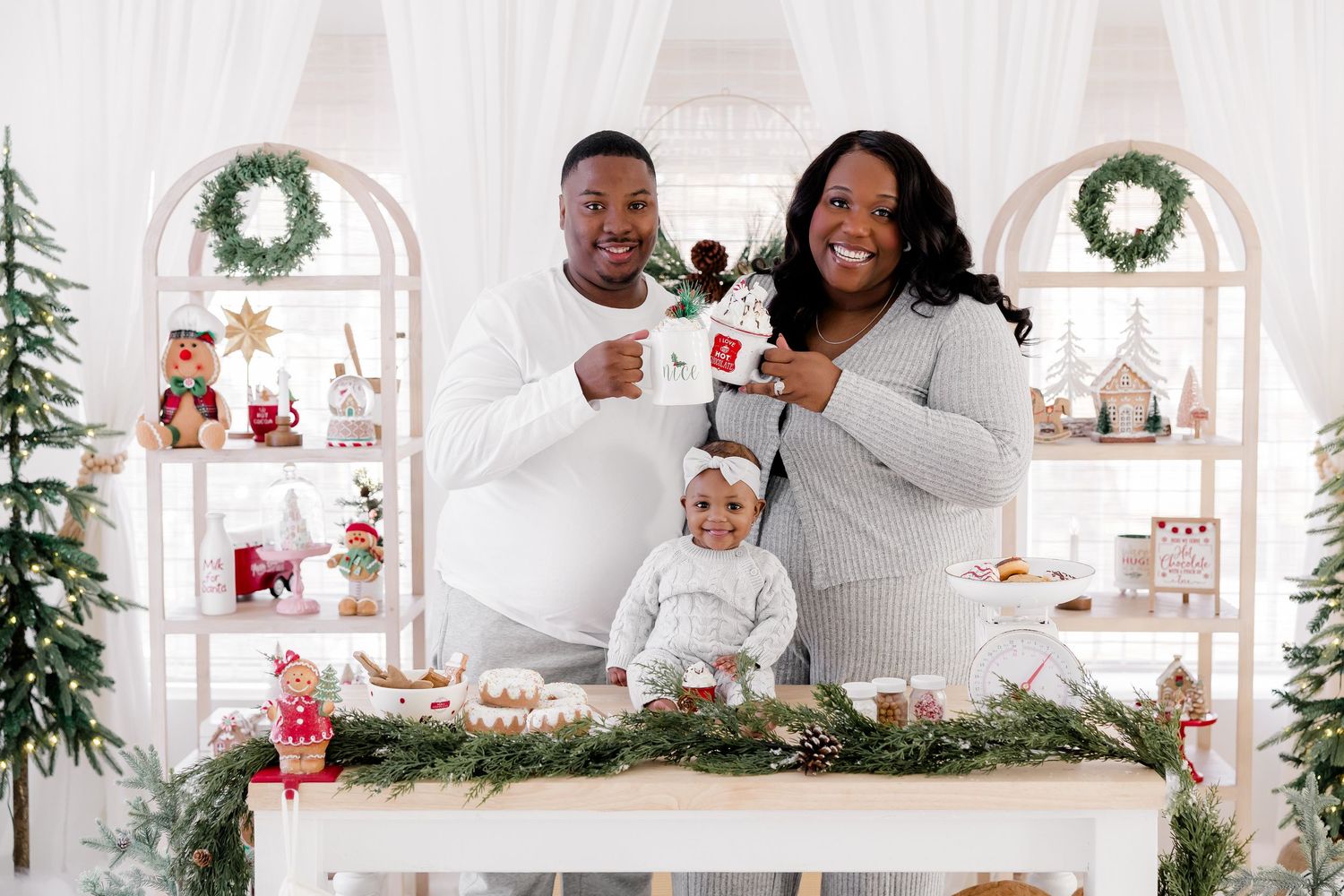 Family holiday portrait with white and green Christmas decor and arched display shelves.nj holiday mini sessions