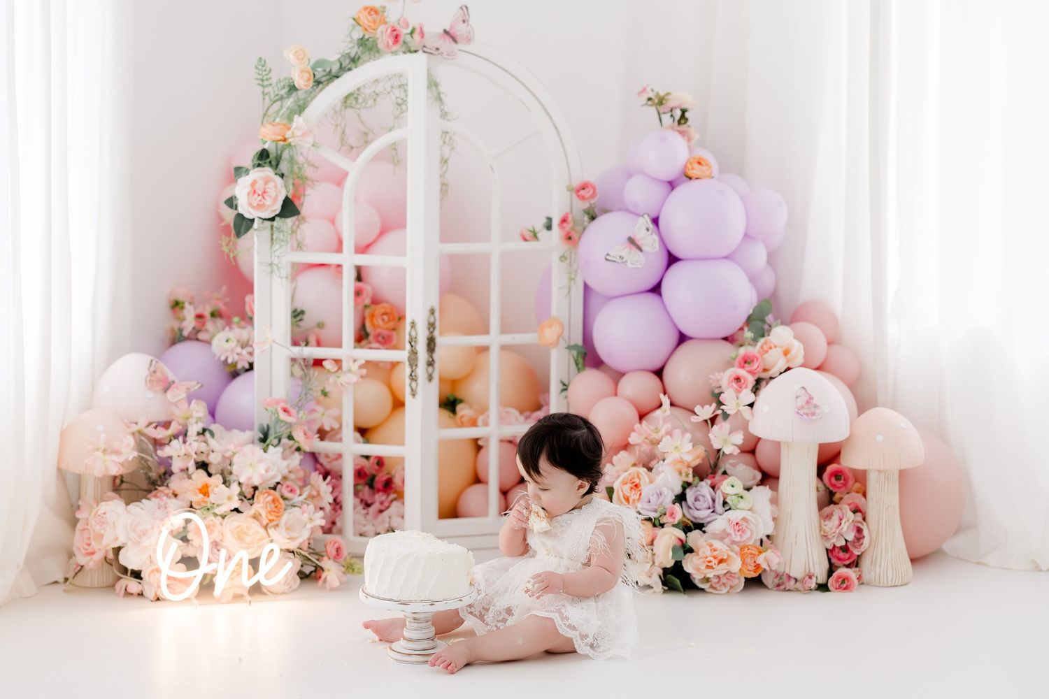 Dreamy pink and white baby nursery corner with floral decorations, plush toys, and window backdrop.