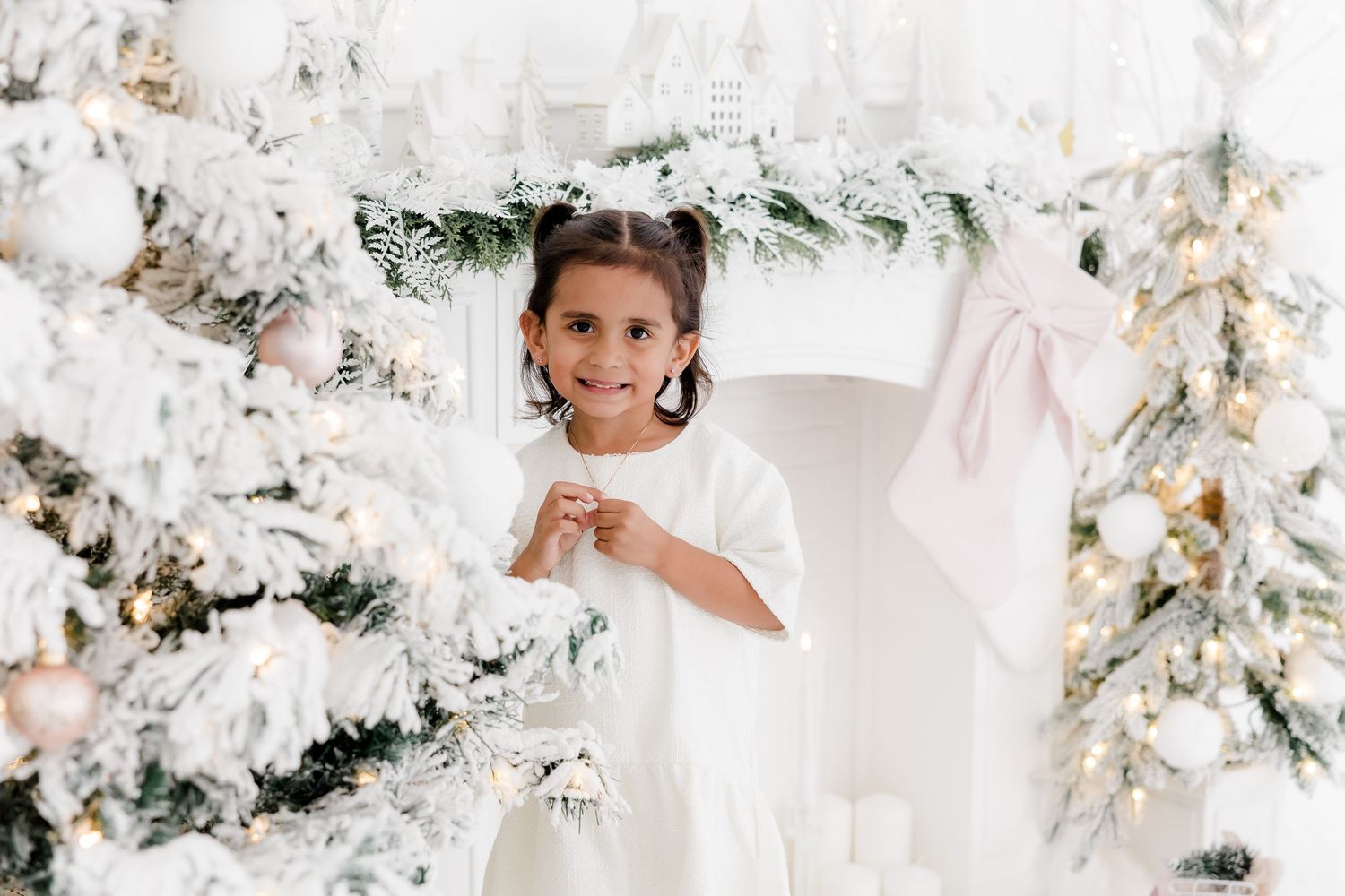 White winter wonderland photoshoot setup with flocked Christmas trees and elegant decor.nj holiday mini sessions