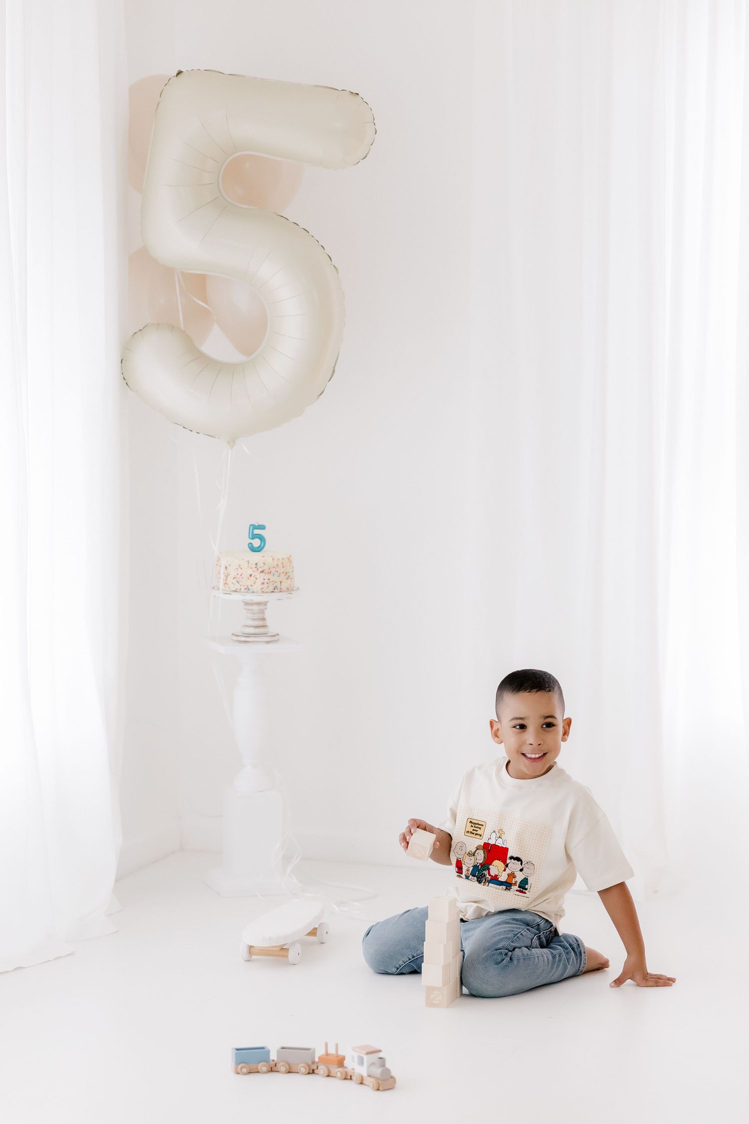 Four minimalist photos of a child playing with wooden number blocks and toys against a white background.