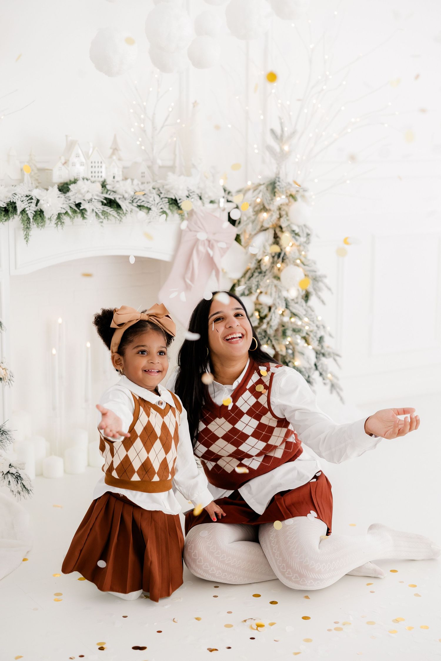 Holiday portrait session with brown and white coordinated outfits against festive decor.
