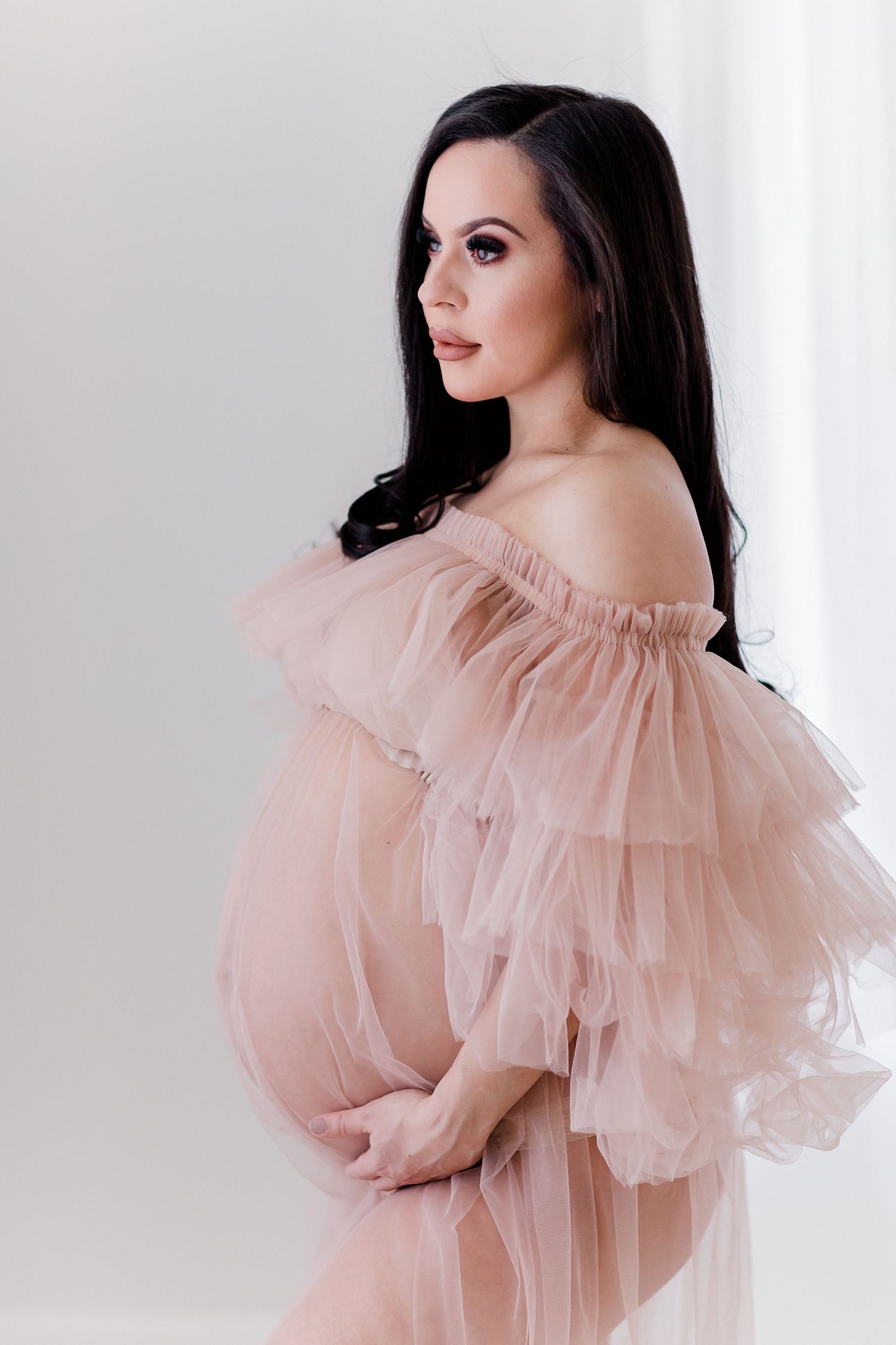 Glamour portrait series featuring ruffled pink tulle gown against white background.
