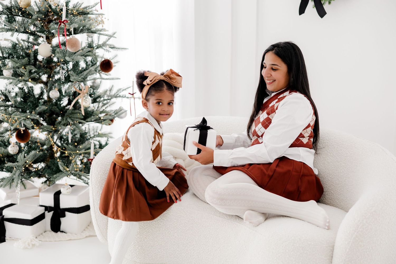 Cozy holiday scene with a decorated Christmas tree and white seating area.