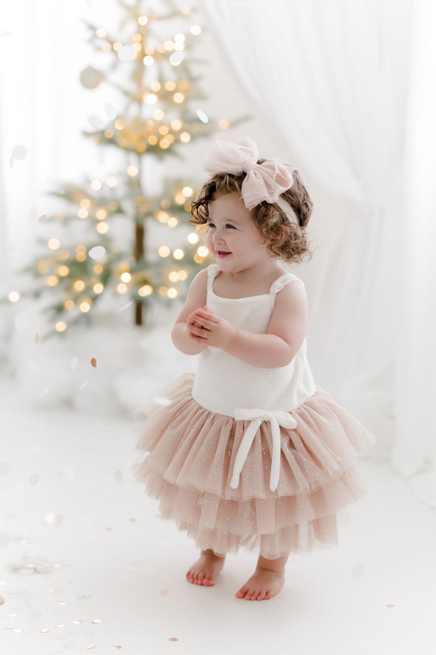 Festive holiday portrait with sparkly Christmas trees and blush tulle dress.