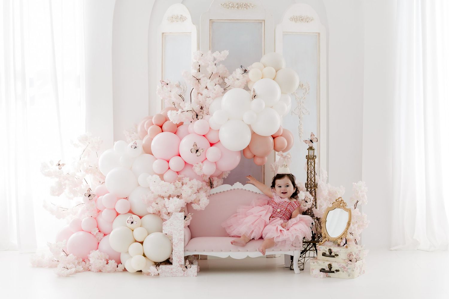 Elegant white and pink floral studio setup with mirrors and romantic cherry blossom decorations.