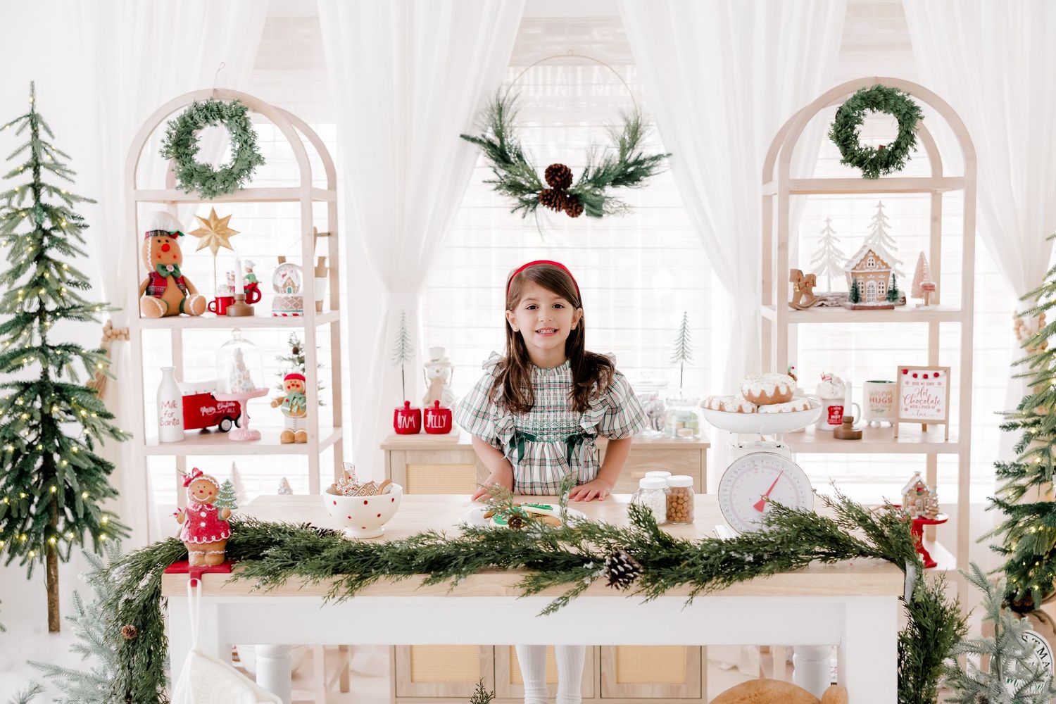 White Christmas display featuring holiday decor, wreaths and festive arrangements on shelving.
