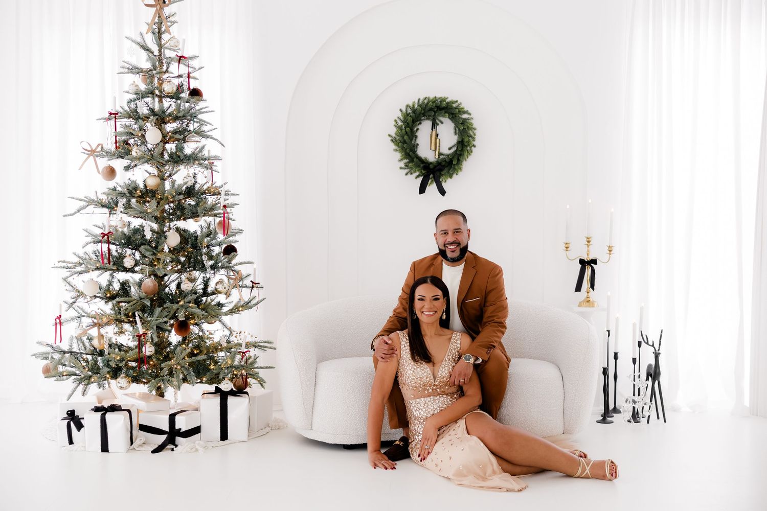 Holiday photo session in white room featuring decorated Christmas trees and elegant party attire.nj holiday mini sessions
