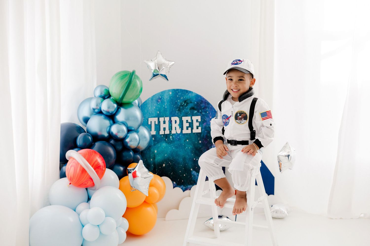 Modern balloon installation in blue and orange tones with white backdrop.