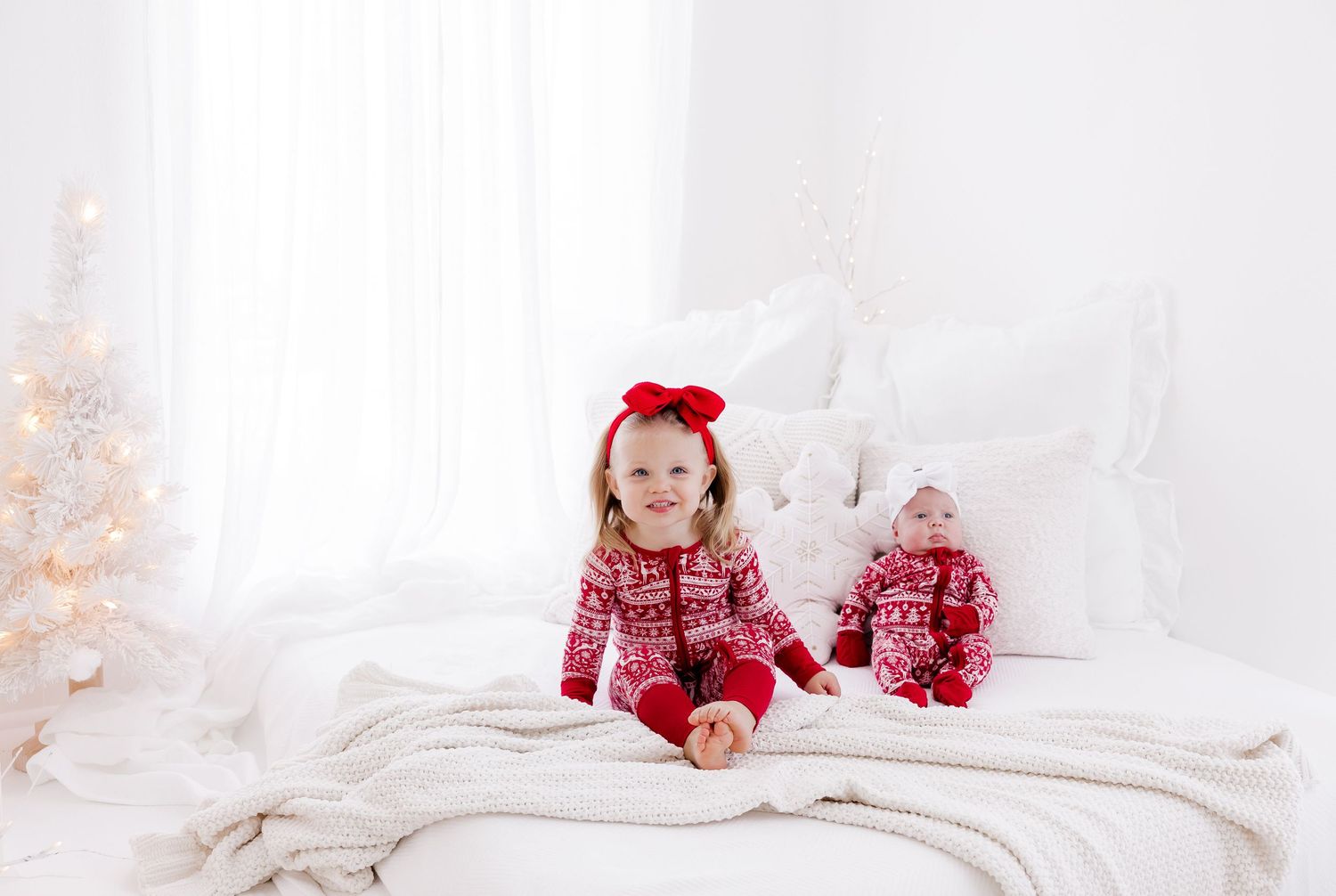 Cozy white studio setting with soft lighting and holiday decorations.