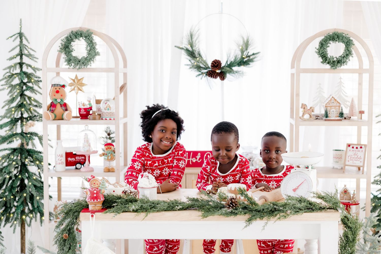 Bright studio space decorated with Christmas trees, wreaths and holiday ornaments.
