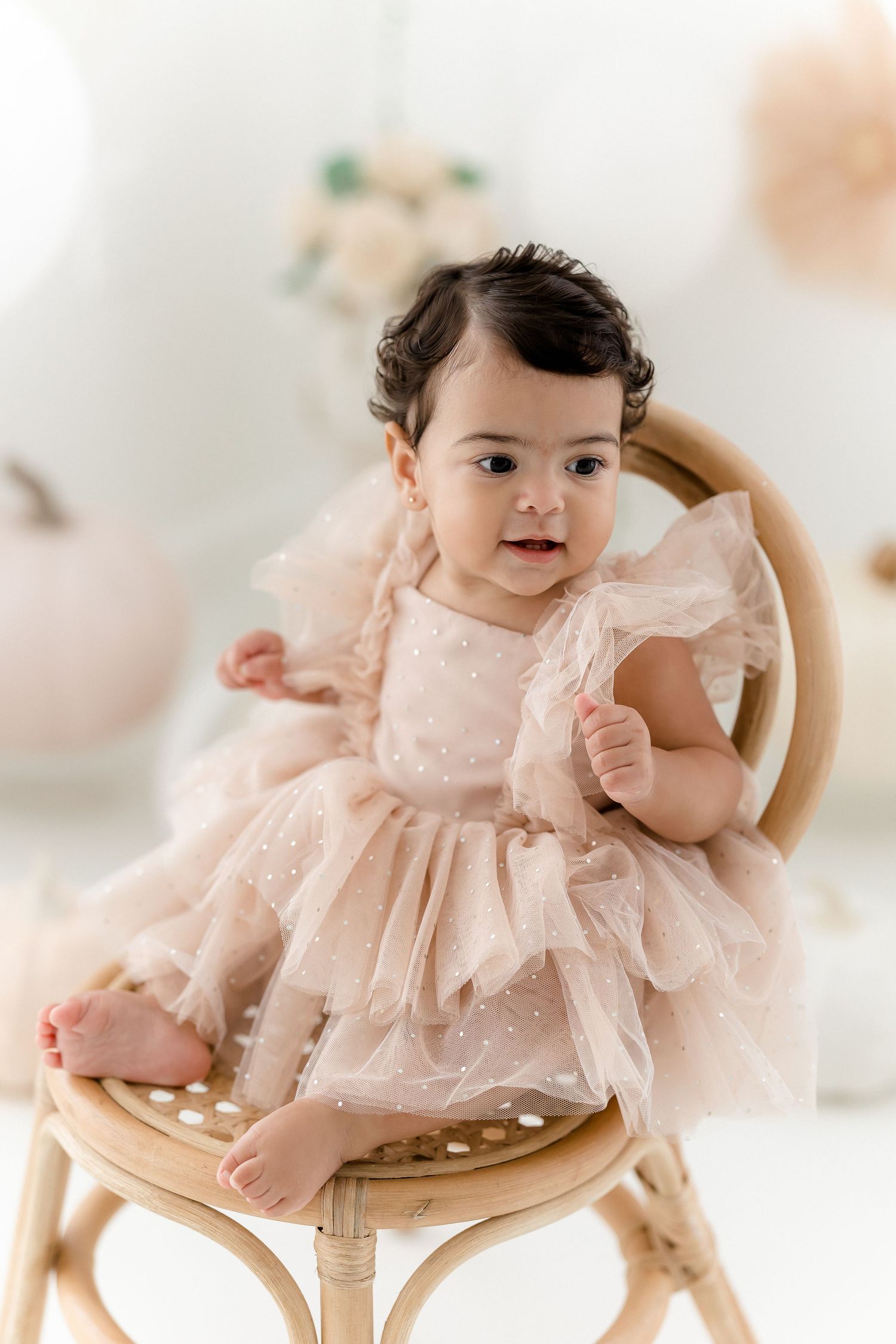 Natural light studio photography featuring wooden chair and pink lace dress.