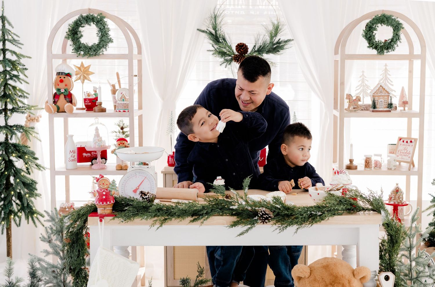 Holiday decorations and greenery adorn a bright white room with Christmas ambiance.