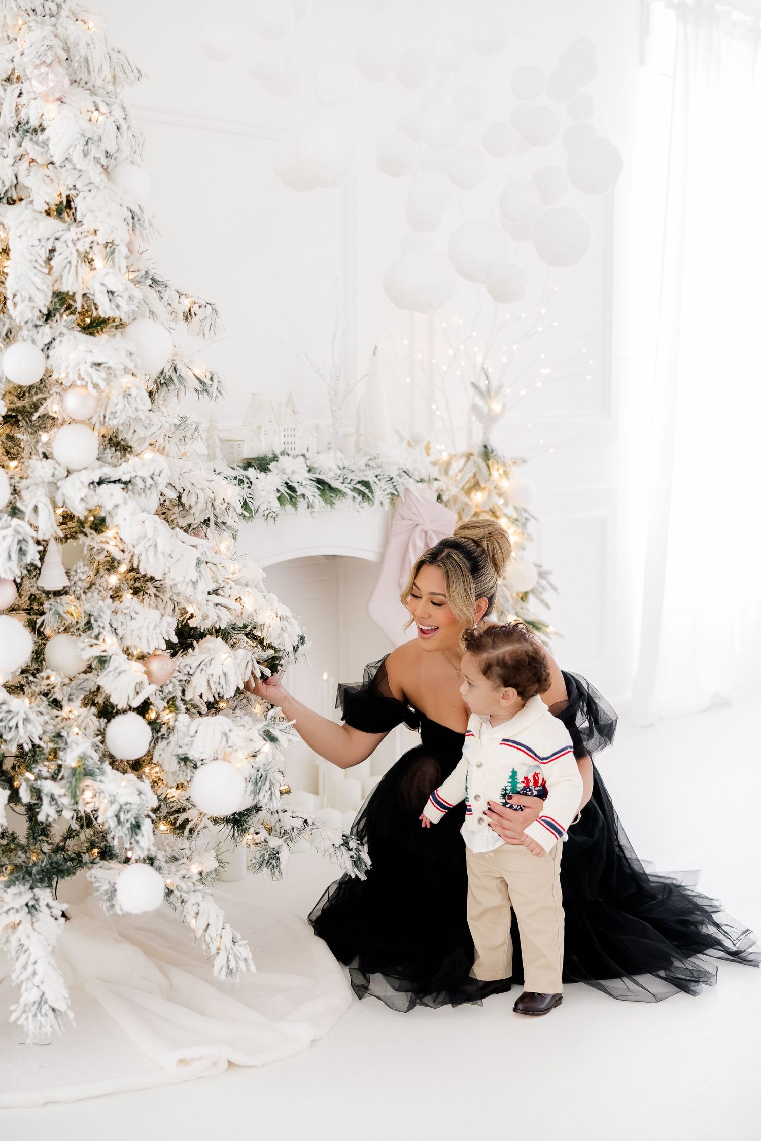 Beautiful holiday scene with mother and child by flocked white Christmas tree.nj holiday mini sessions